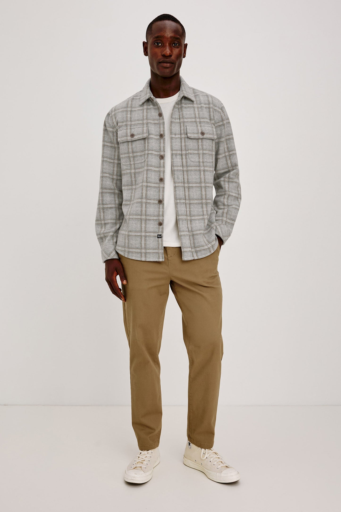 Male model wearing Rails Alder grey plaid flannel overshirt with khaki chinos and white sneakers