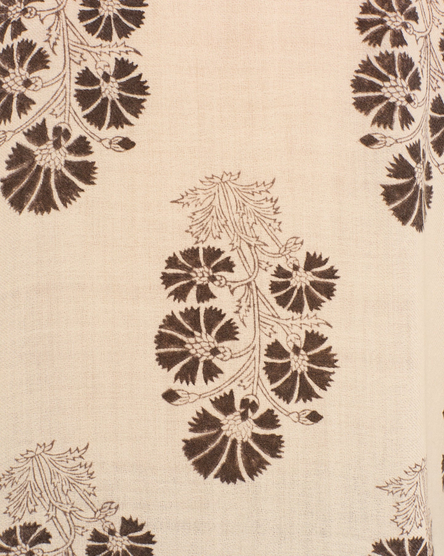 Close-up detail of cream fabric with brown floral pattern featuring radiating petal designs