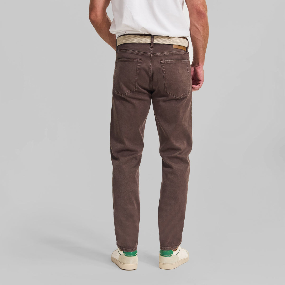 Back view of man wearing brown Rye 51 Sedona washed 5-pocket pants with white belt