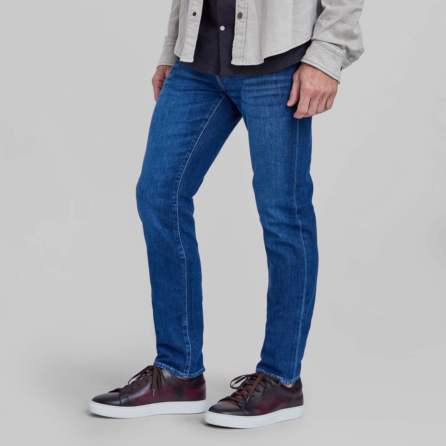 Model wearing Rye 51 Candiani Italian stretch denim jeans in Parma wash with brown sneakers