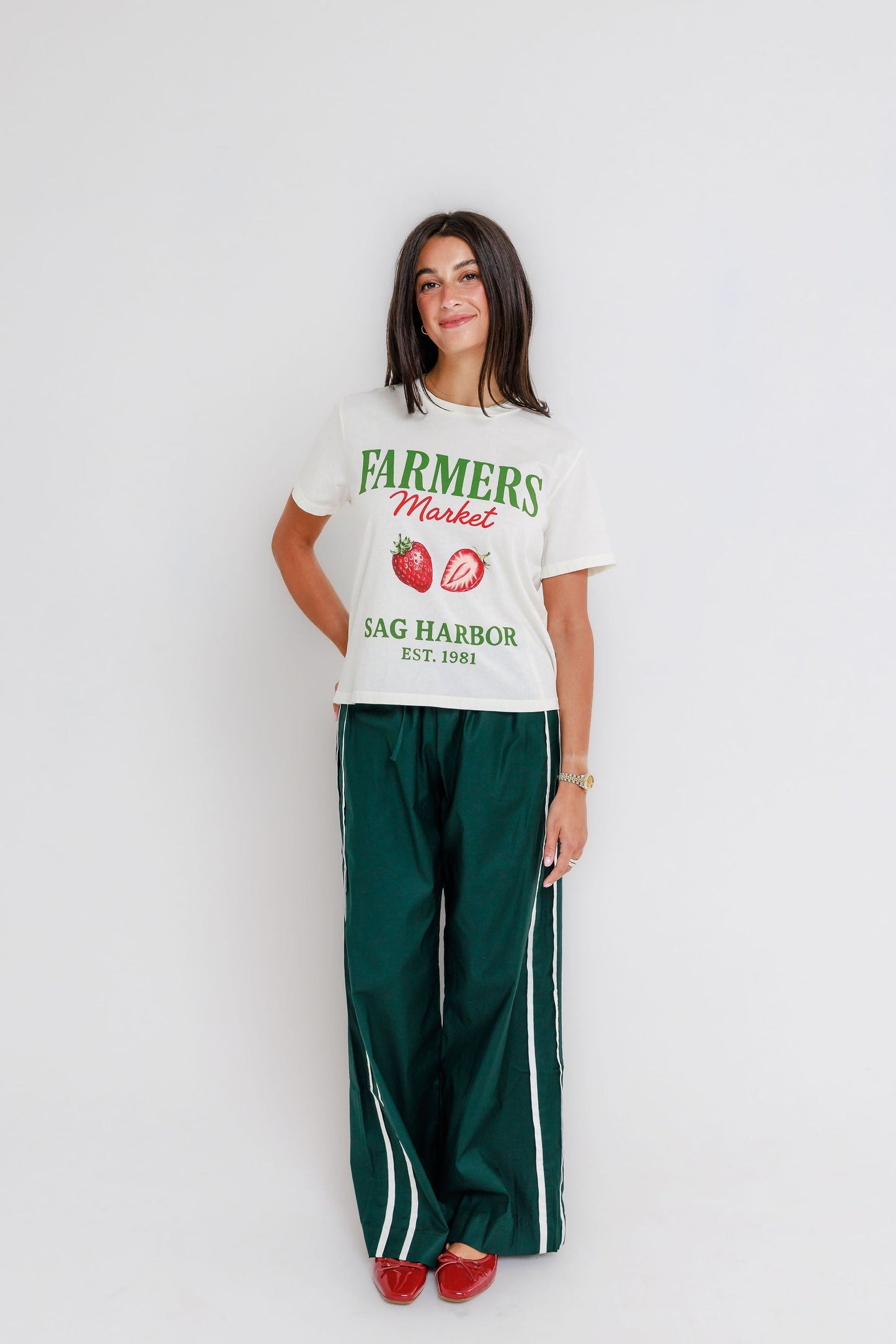 Model wearing cream Farmers Market Sag Harbor Est. 1981 graphic tee with strawberry illustration