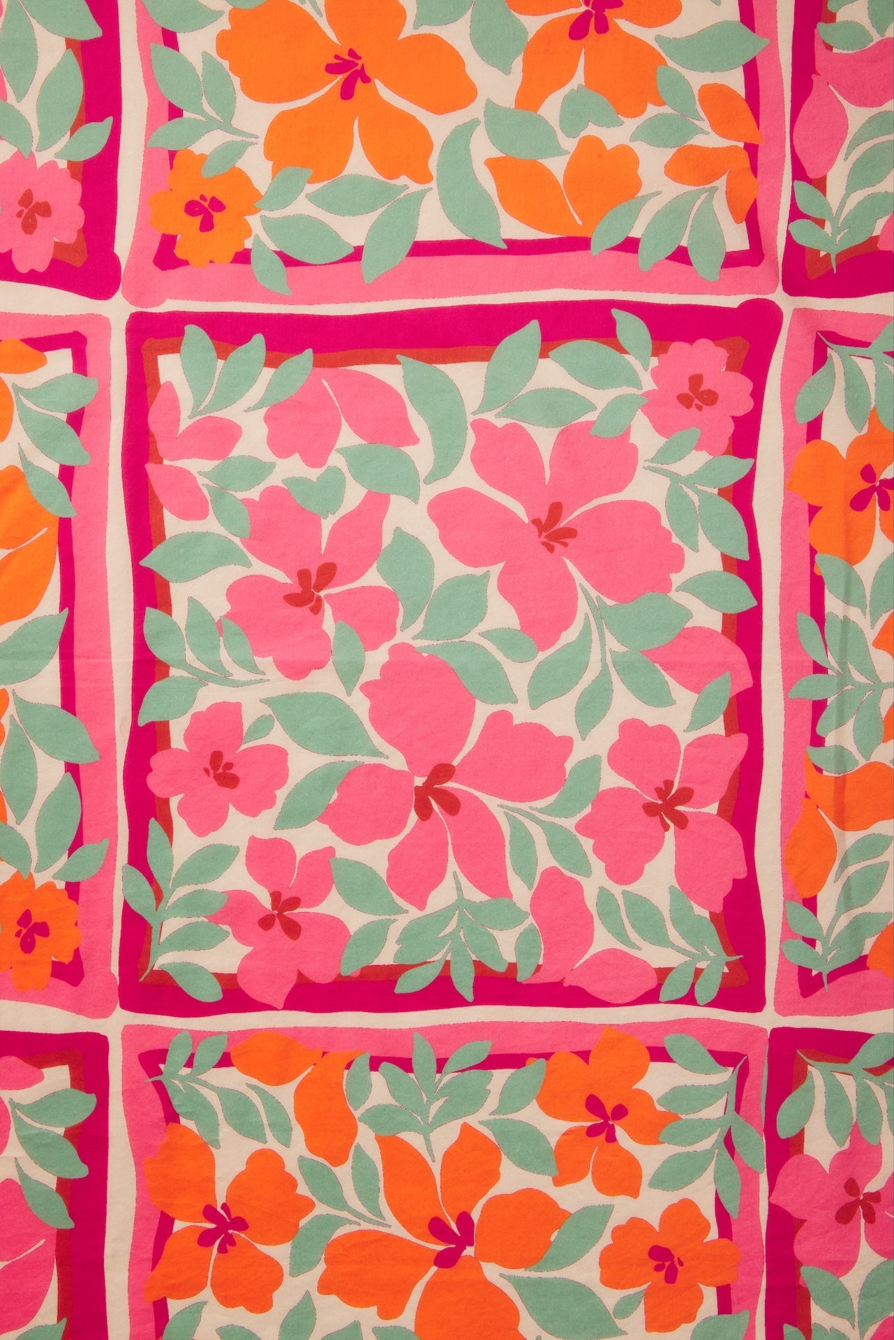 Vibrant floral fabric swatch featuring pink and orange hibiscus flowers with green leaves on cream background