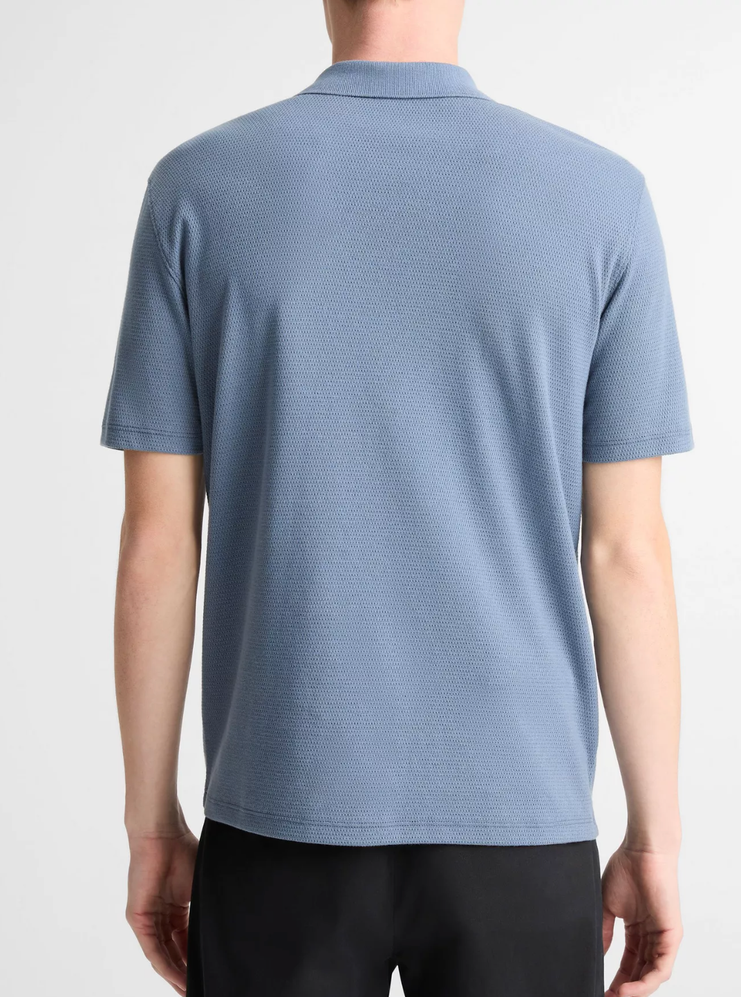 Back view of man wearing Vince SS Johnny short-sleeve polo shirt with collar in light blue textured fabric.