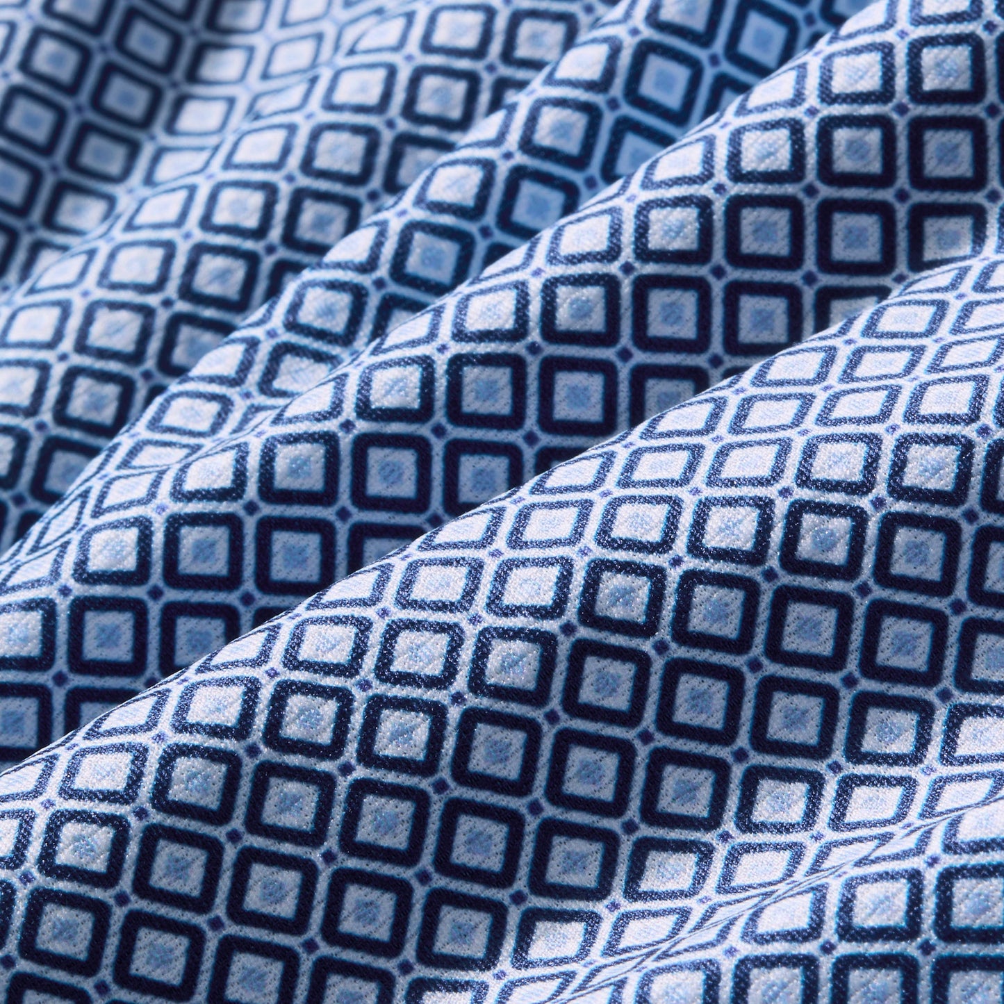 Close-up swatch of navy blue fabric with enlarged diamond geometric pattern