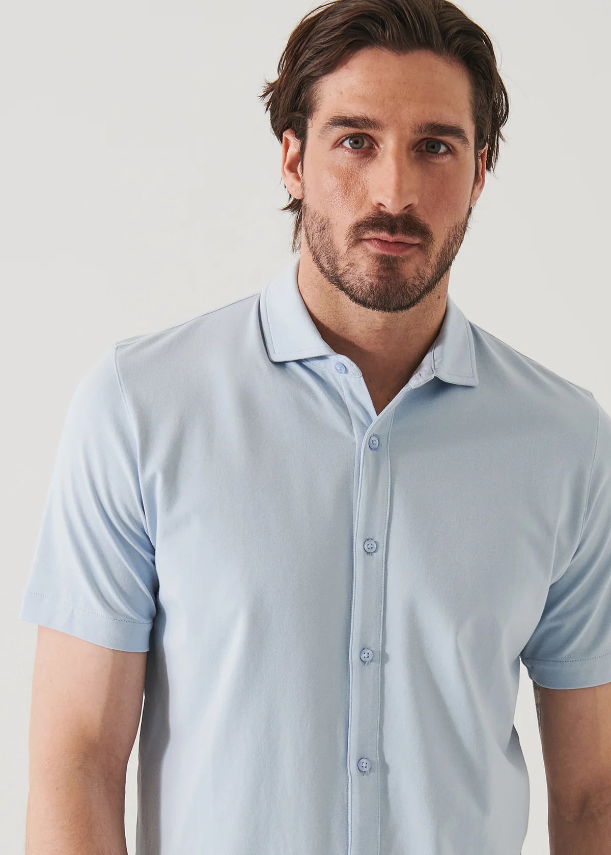 Patrick Assaraf men's light blue short-sleeve button-front shirt with spread collar, modeled by brunette man.