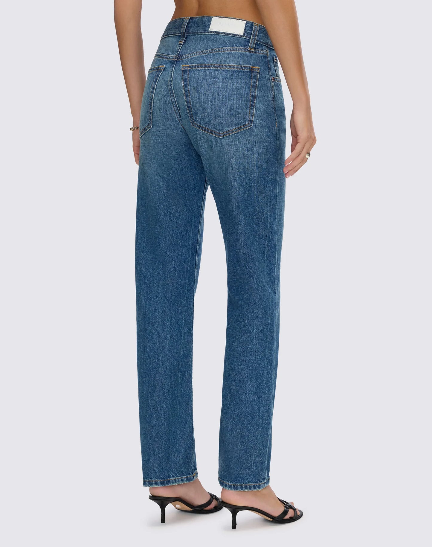 Re/Done mid-rise straight leg cropped jeans shown from behind, featuring classic five-pocket styling and white label patch.