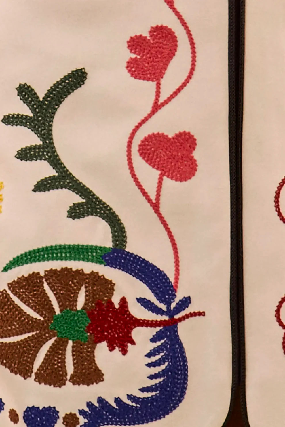 Embroidered mini skirt with colorful floral and botanical motifs featuring detailed stitching on cream fabric by Hunter Be...