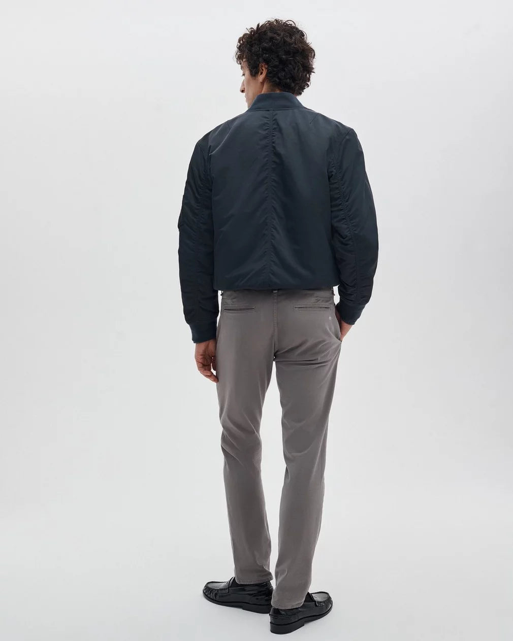 Rag & Bone Fit 3 Stretch Twill Chinos in grey, shown from behind on male model with navy bomber jacket.