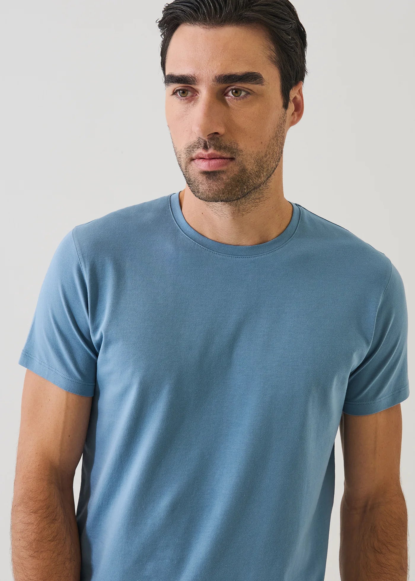 Man wearing Patrick Assaraf short sleeve pima cotton crew neck t-shirt in light blue against neutral background