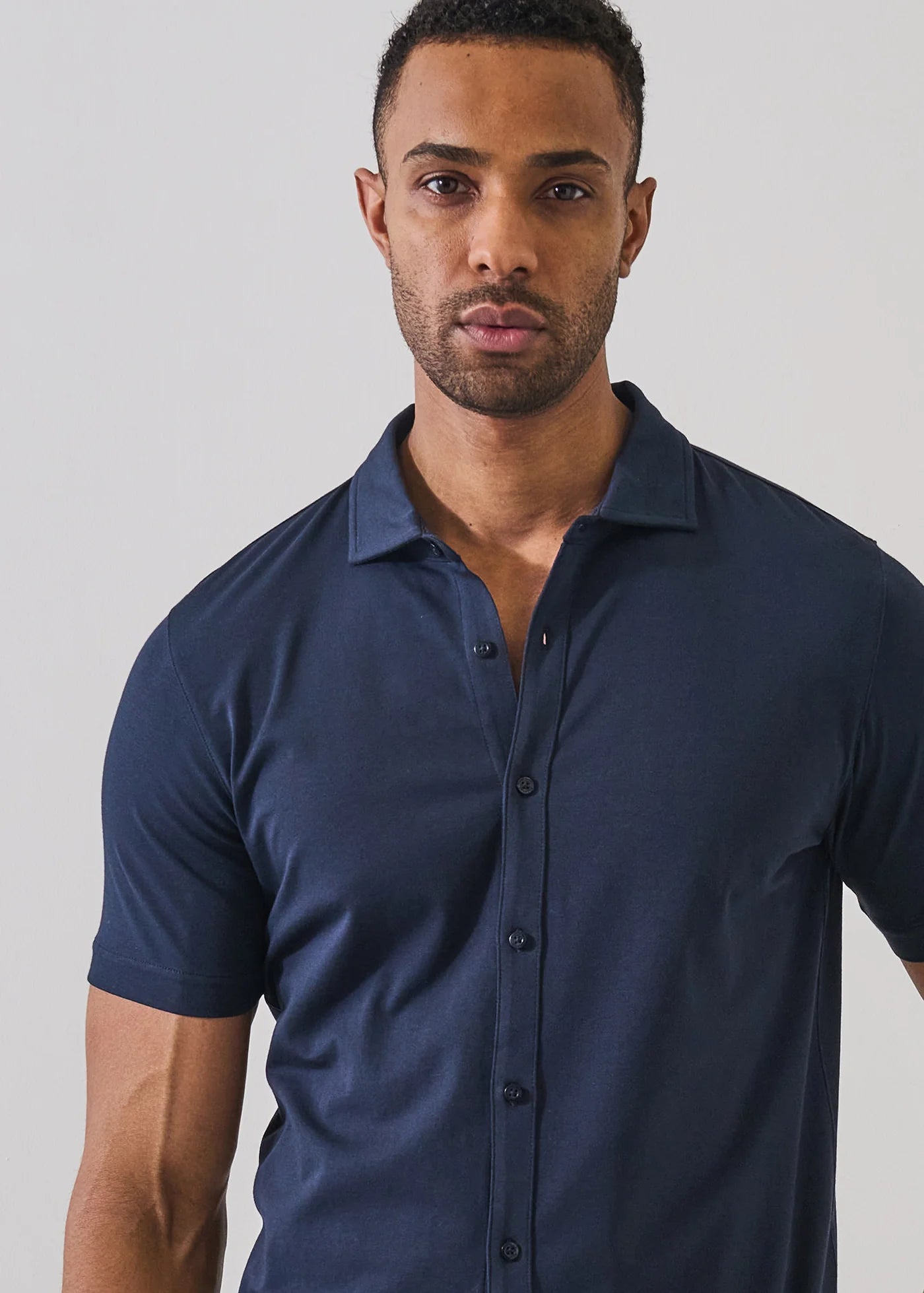 Patrick Assaraf short sleeve button-up shirt in navy blue with spread collar and fitted silhouette.