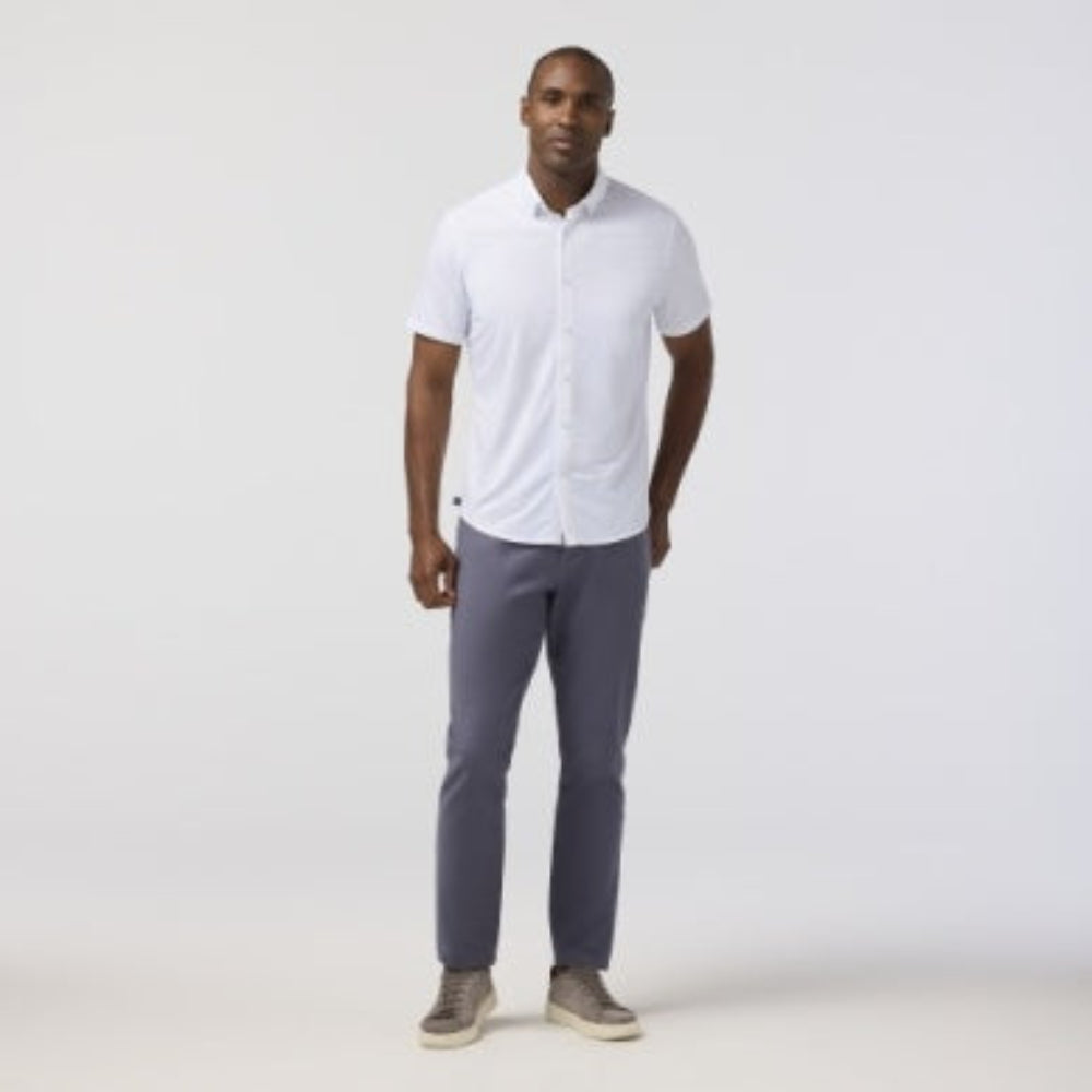 Man wearing white short sleeve collared shirt with gray pants and sneakers
