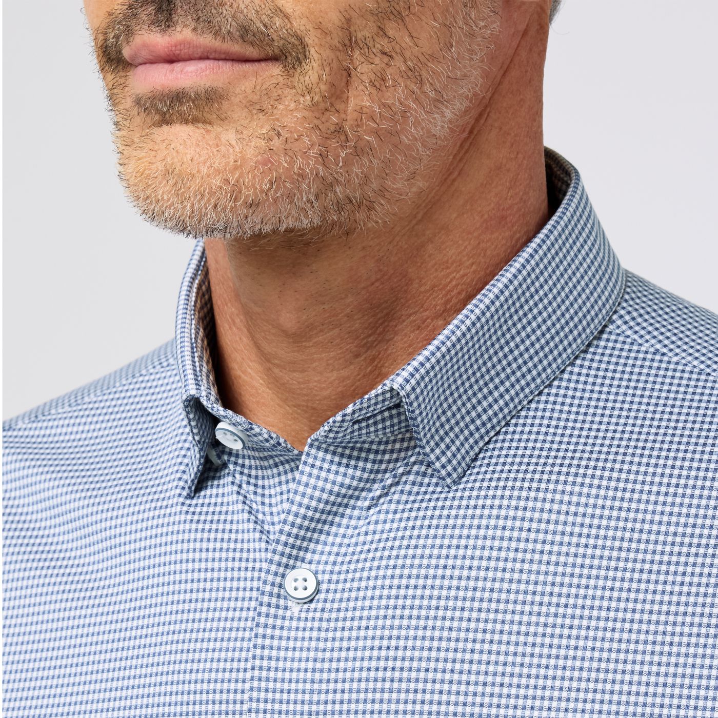 Man wearing Mizzen+Main Halyard short sleeve dress shirt in blue and white gingham check pattern