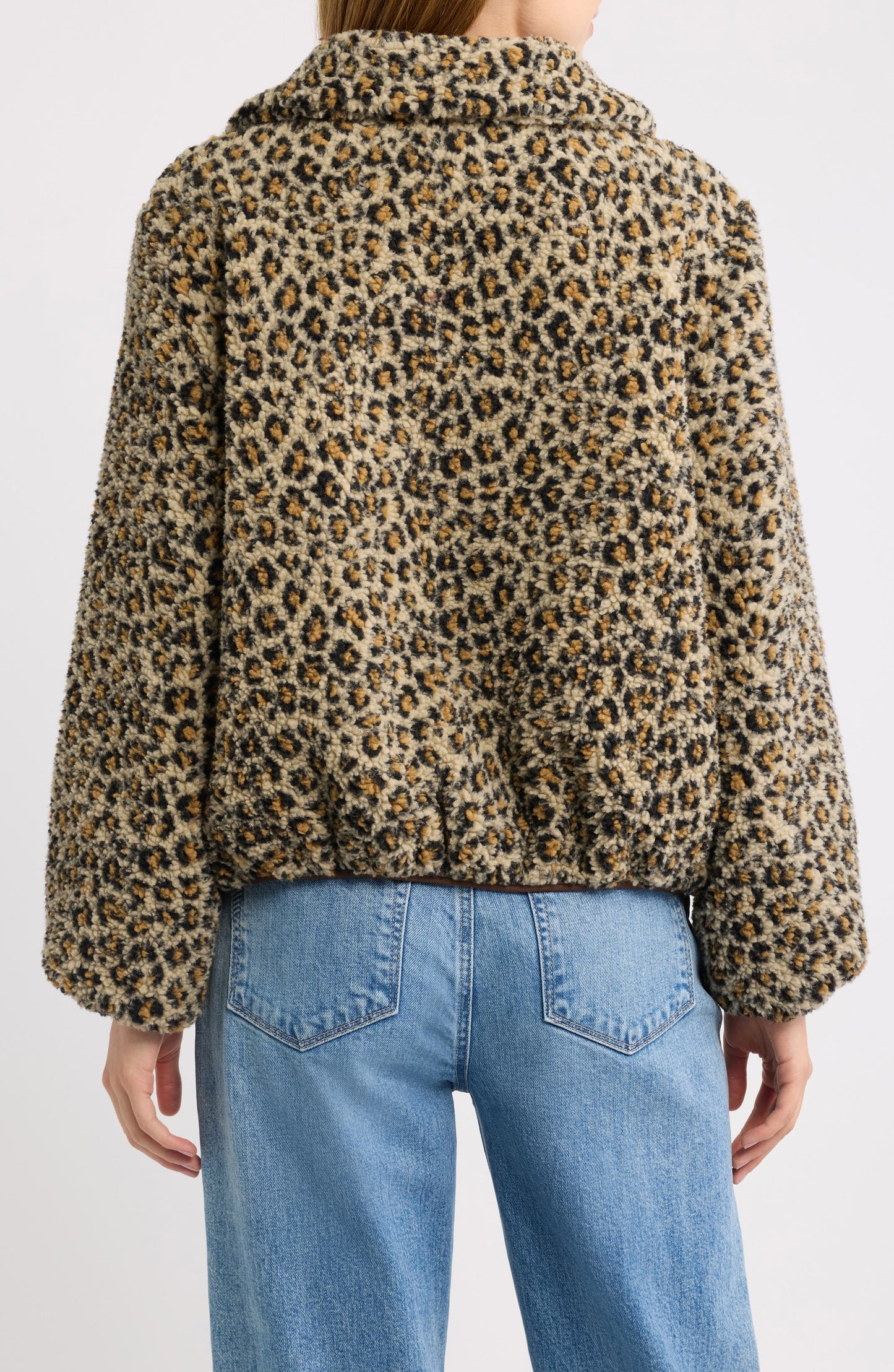 Back view of tan leopard print fleece jacket paired with blue jeans
