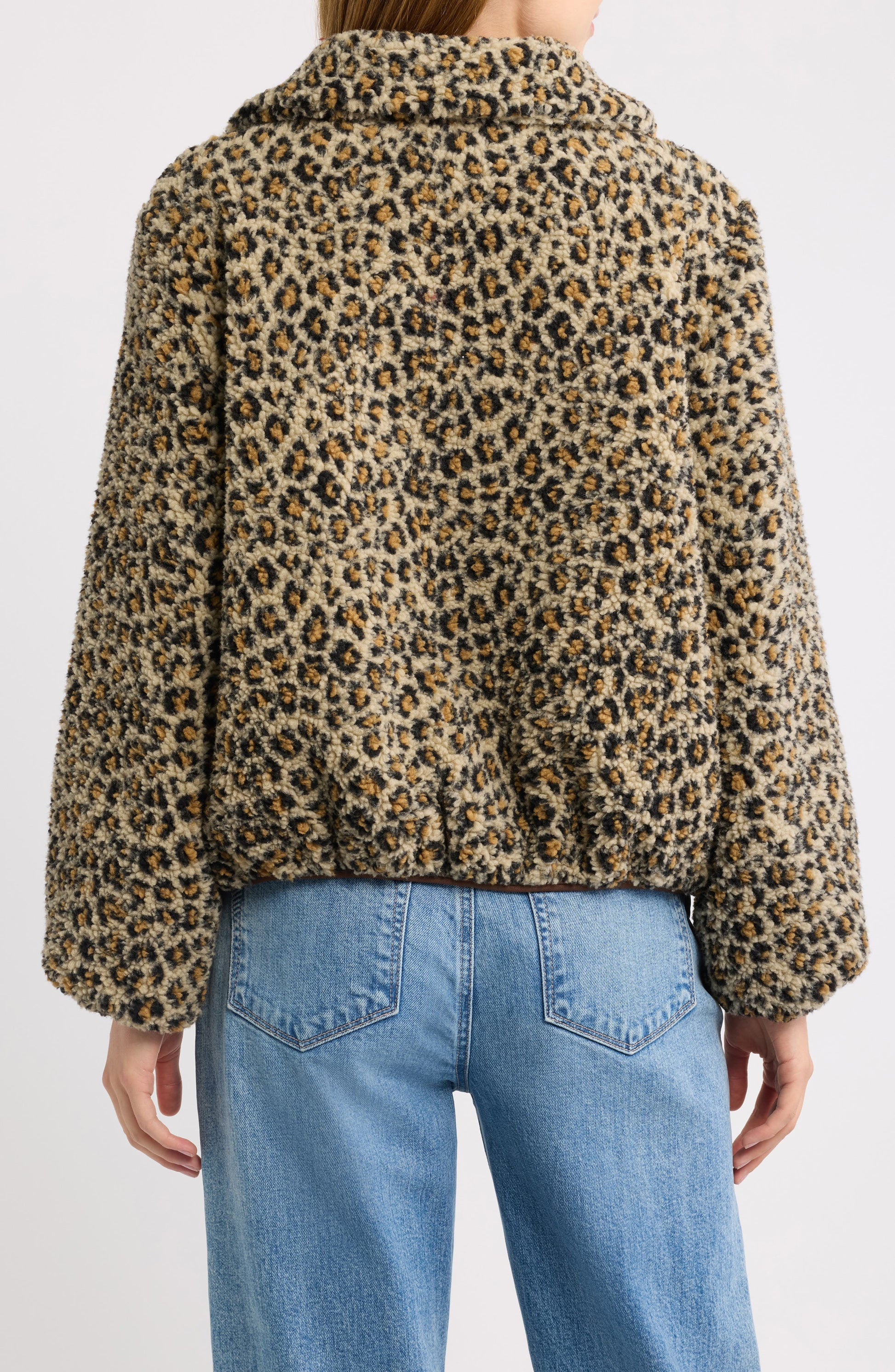 Back view of tan leopard print fleece jacket paired with blue jeans