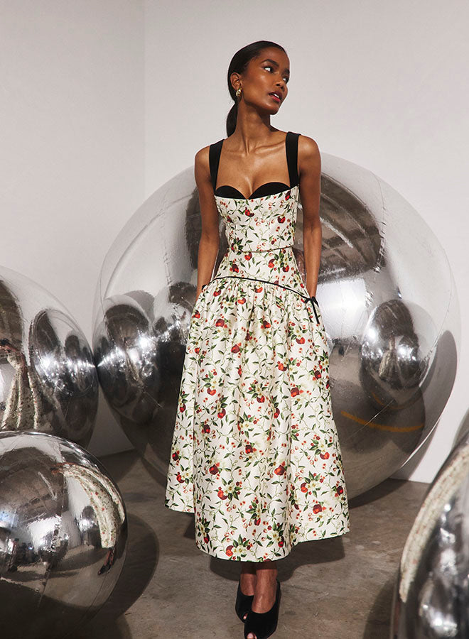 Model wearing Hunter Bell Nolita ivory floral midi skirt with black bustier top and heels