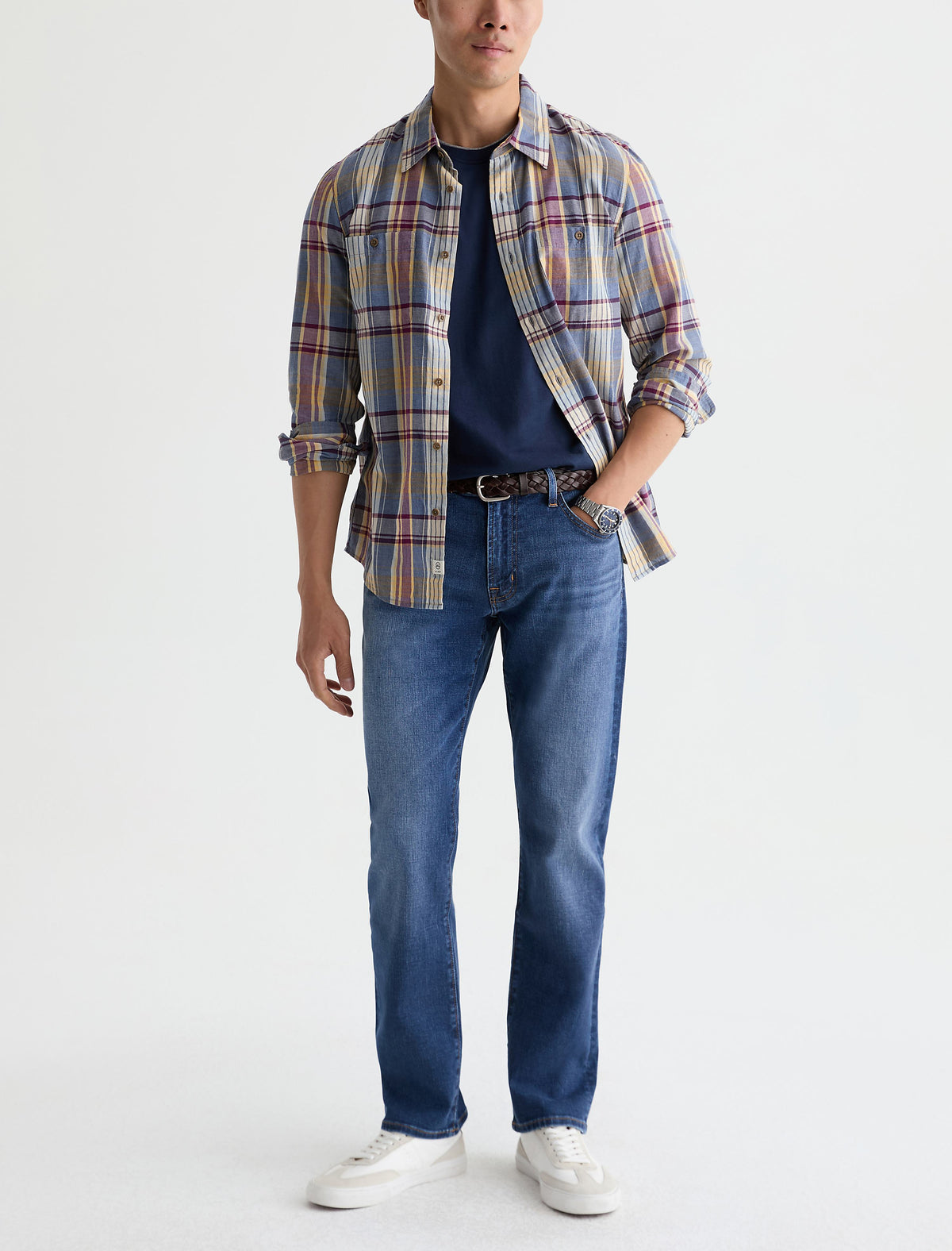 Man wearing AG Graduate tailored leg jeans in medium blue wash with plaid shirt