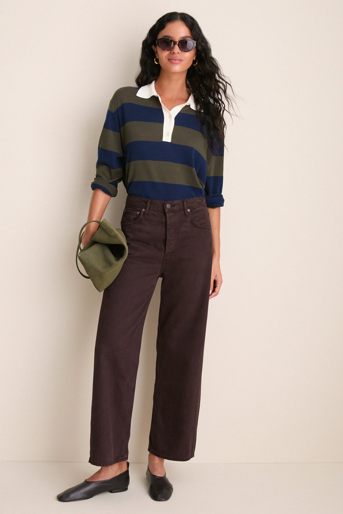 Model wearing olive and navy striped rugby polo sweater with white collar and buttons