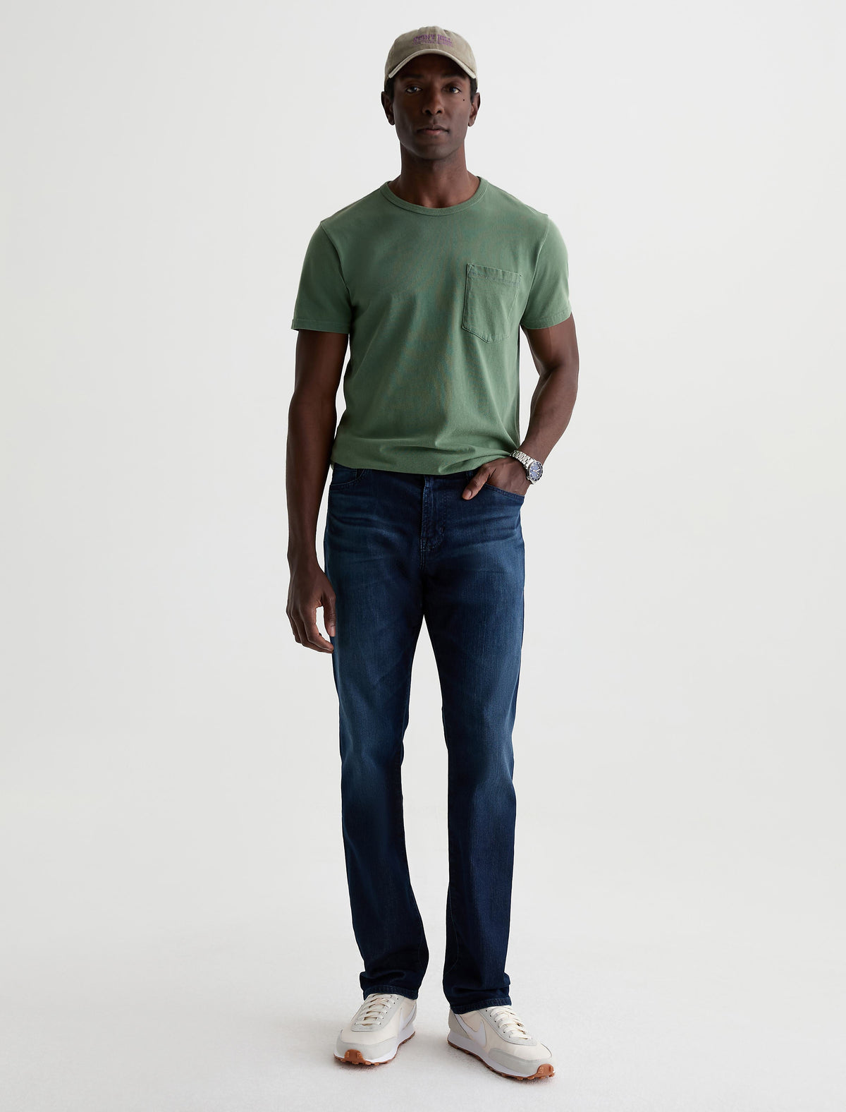 Man wearing dark blue AG Everett jeans with green t-shirt and sneakers