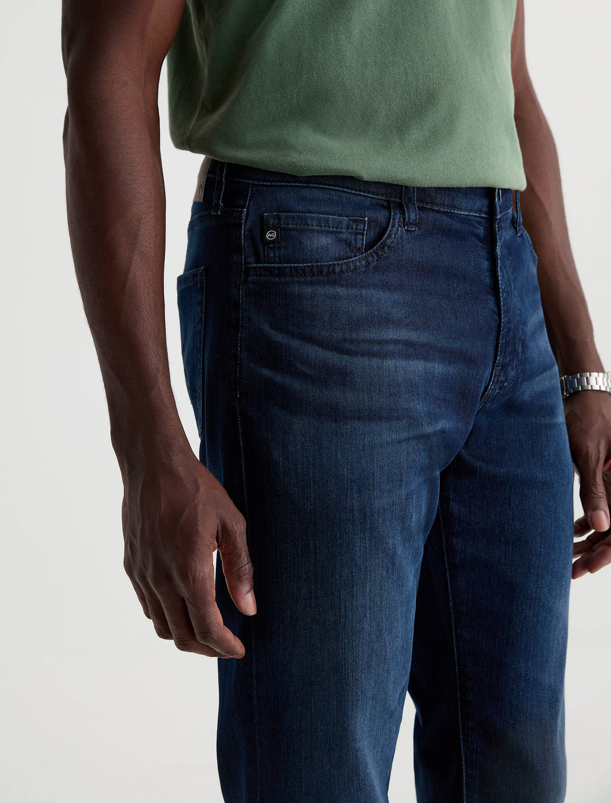 Close-up of man wearing AG Everett slim straight jeans in dark wash with green shirt