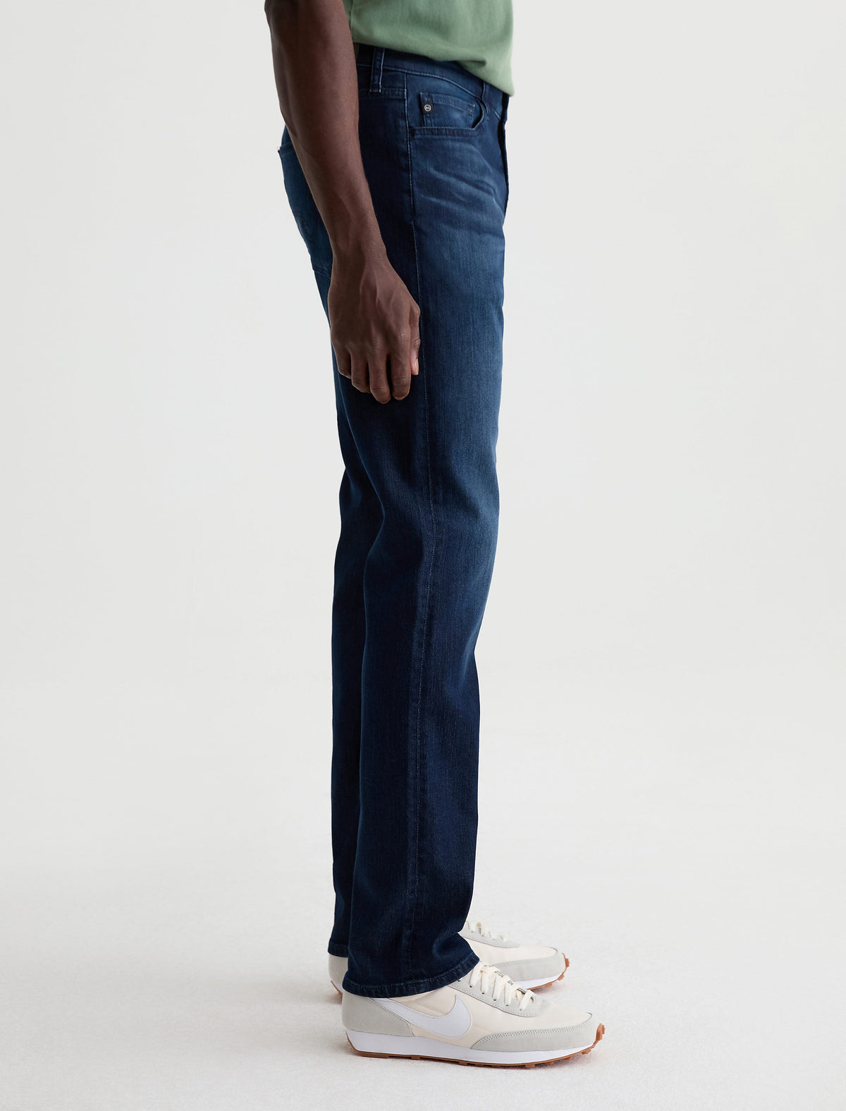 Side view of man wearing AG Everett slim straight jeans in dark blue wash