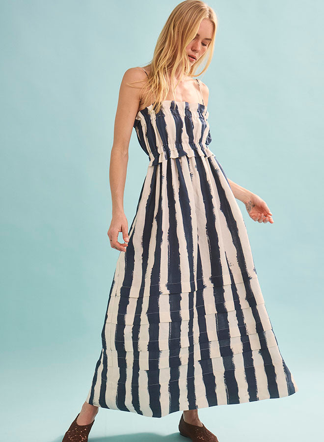 Woman wearing navy and white striped strapless maxi dress with elastic waist