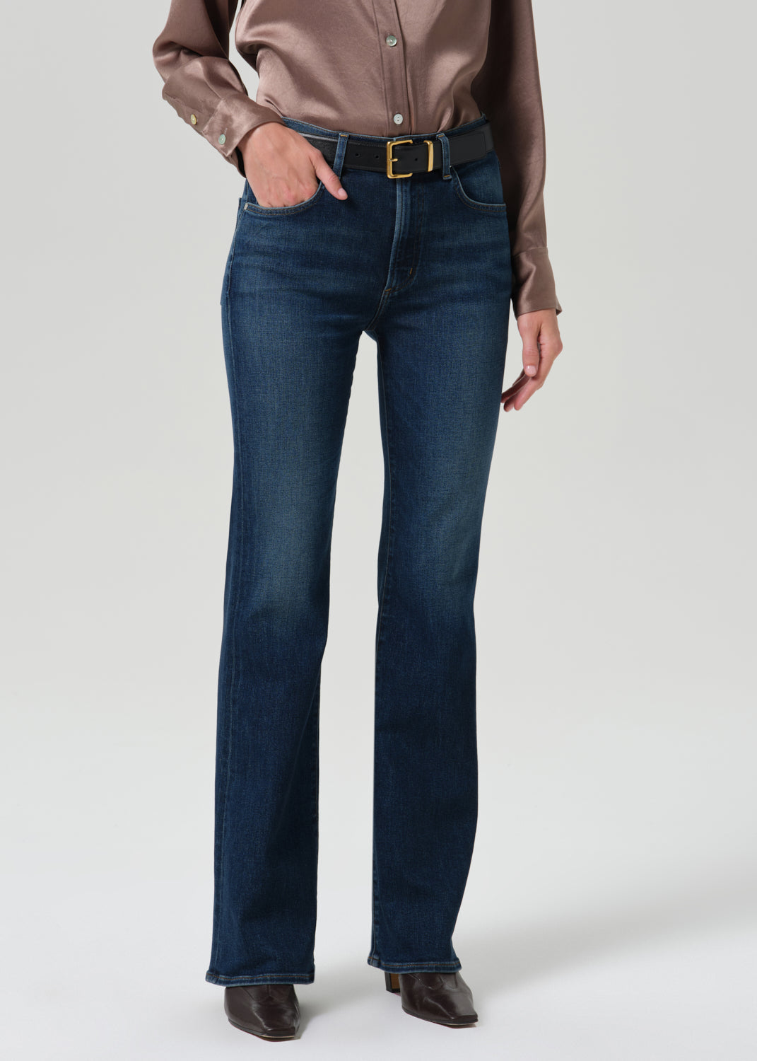 Model wearing Citizens of Humanity Lilah high rise bootcut jeans in dark indigo moonlight wash with black belt