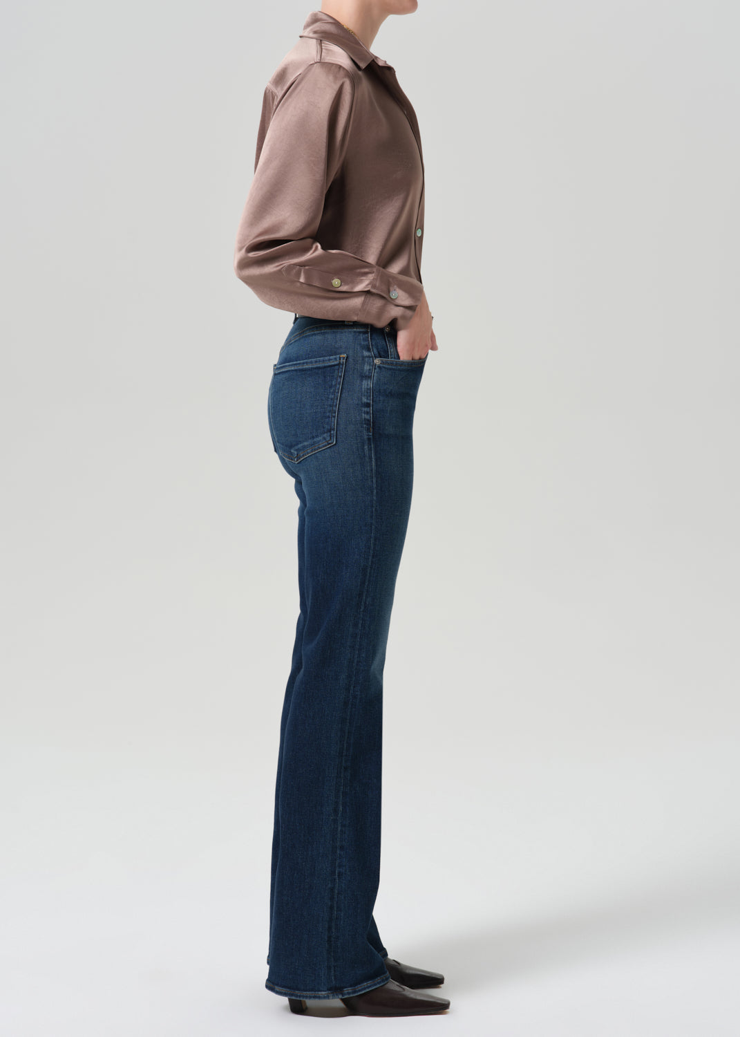 Side view of model wearing Citizens of Humanity Lilah high rise bootcut jeans in dark indigo Moonlight wash