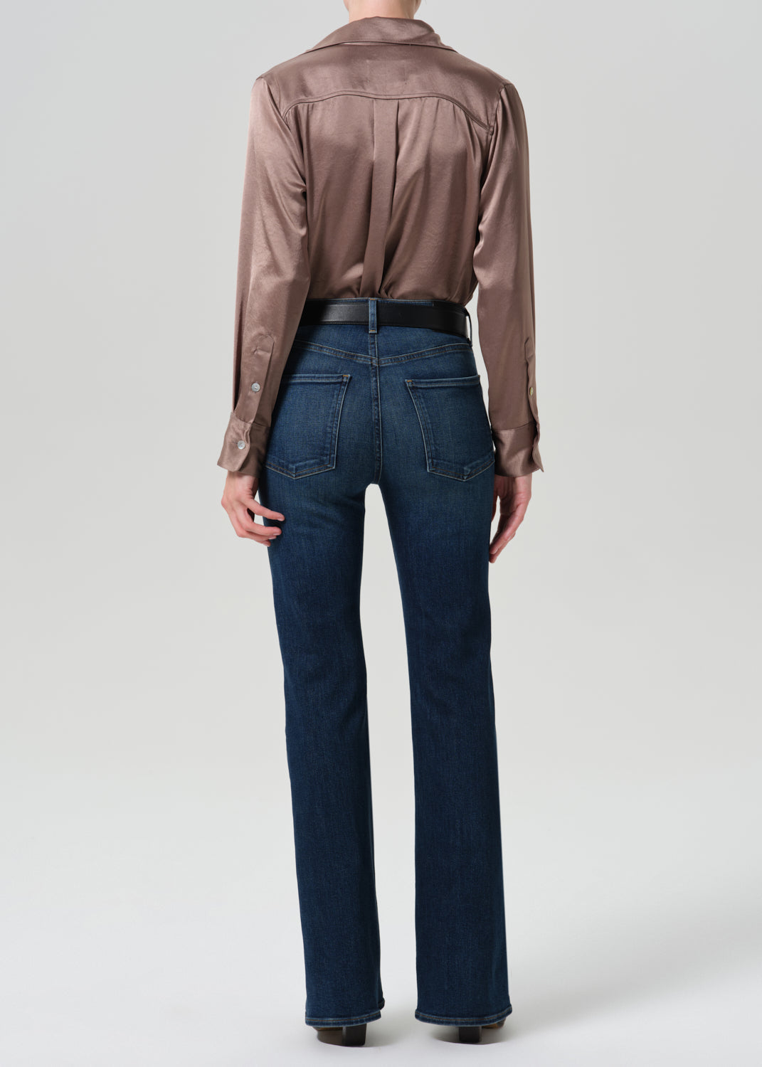 Back view of model wearing Citizens of Humanity Lilah high rise bootcut jeans in dark indigo Moonlight wash with satin blouse