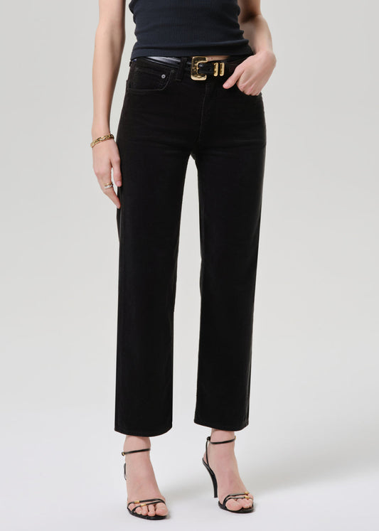 Model wearing Citizens of Humanity Palma straight-leg black corduroy jeans with gold belt and strappy heels