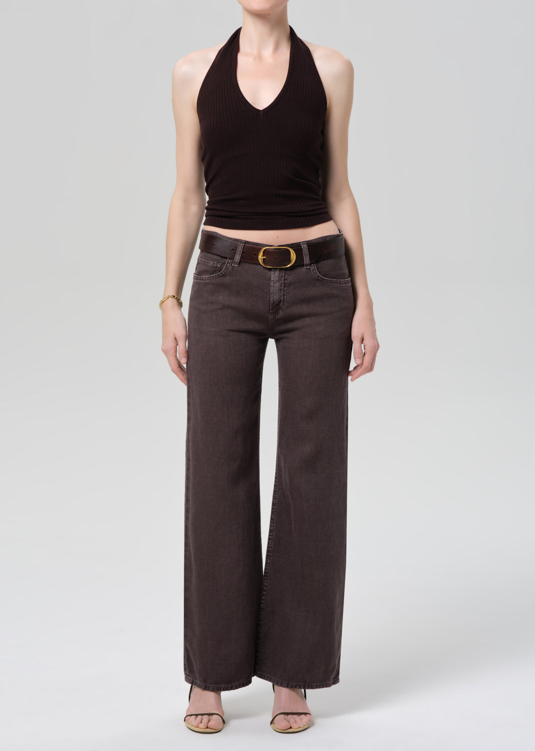 Model wearing charcoal gray wide-leg trousers with black halter top and belt