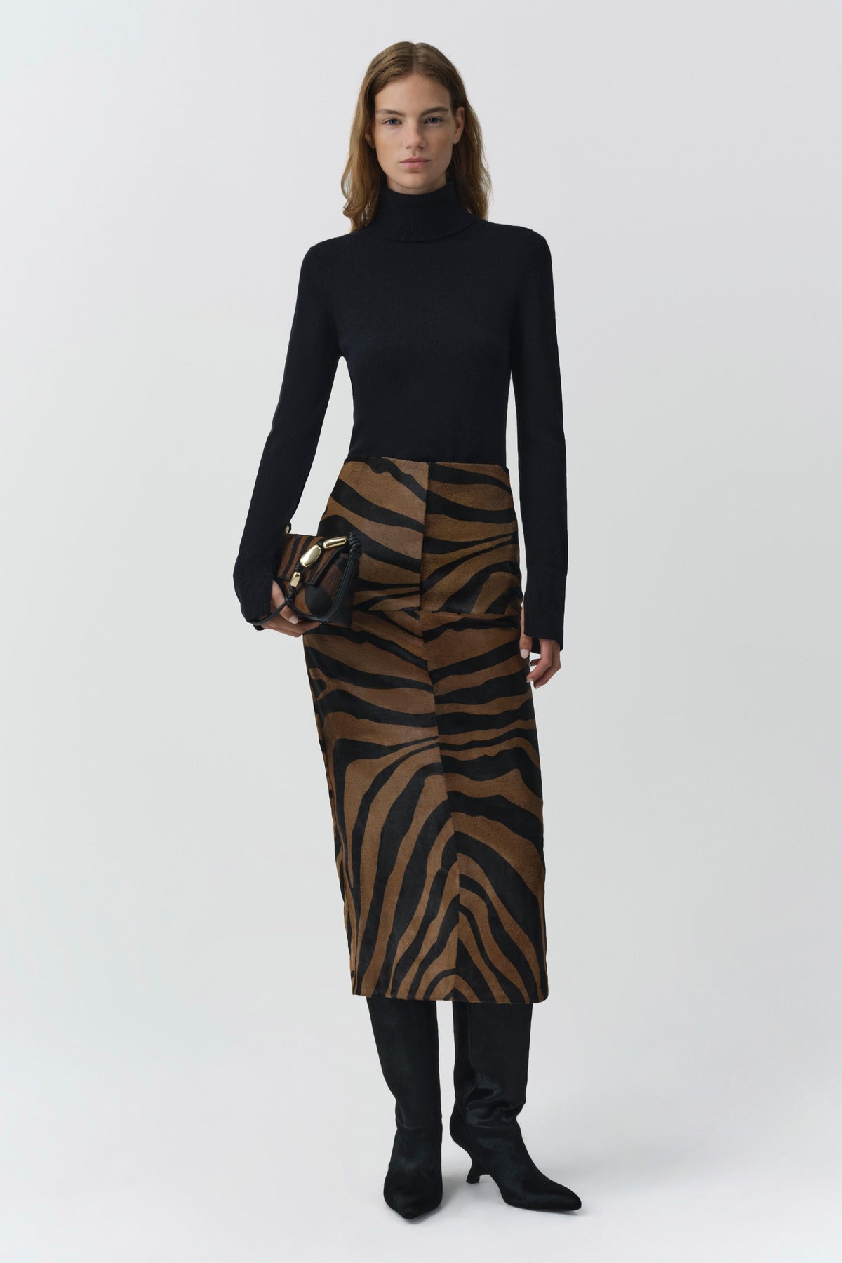 Model wearing black cashmere turtleneck with tiger print midi skirt and black boots
