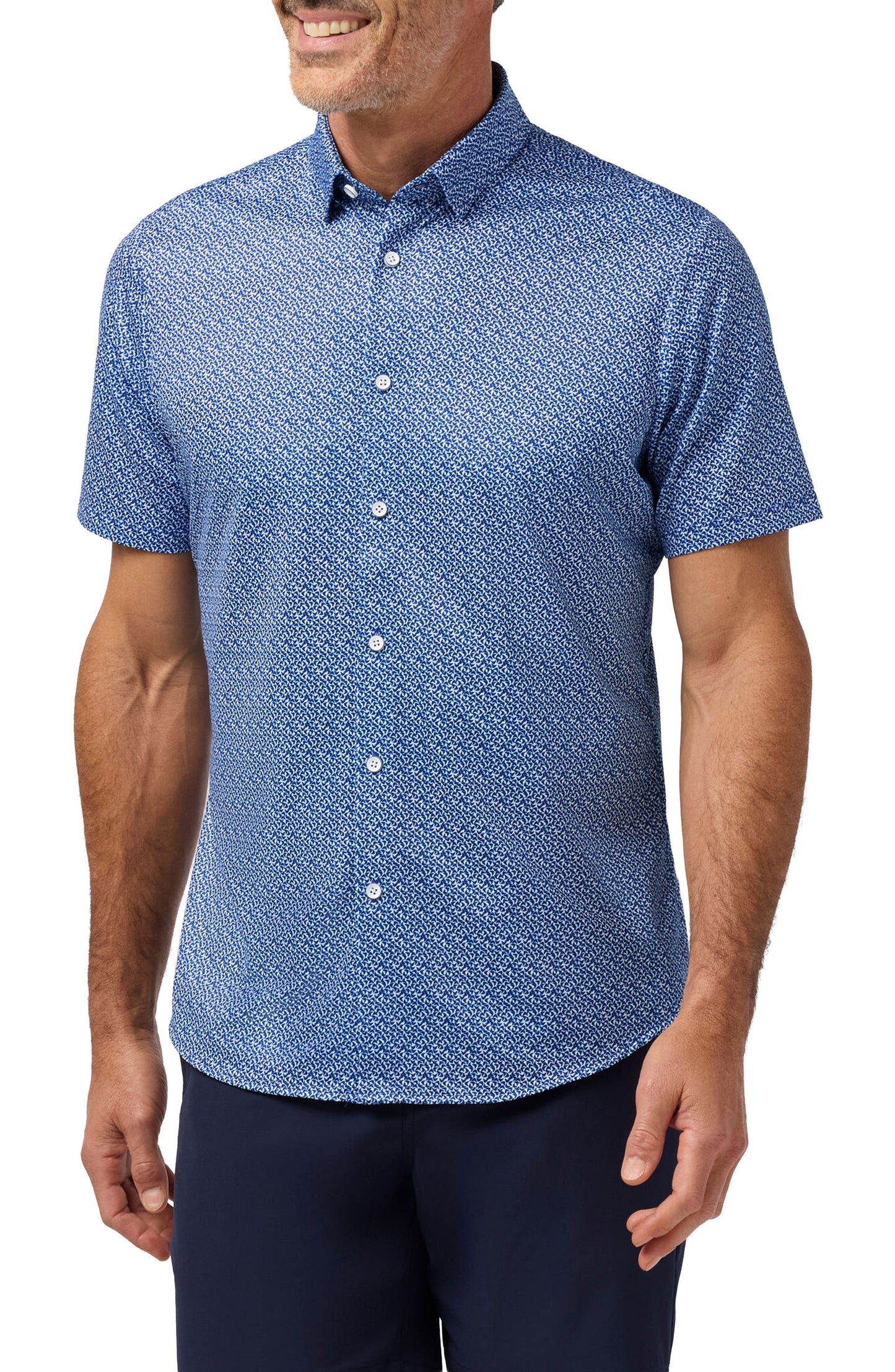 Man wearing cobalt blue short sleeve button-up shirt with small retro boomerang print pattern