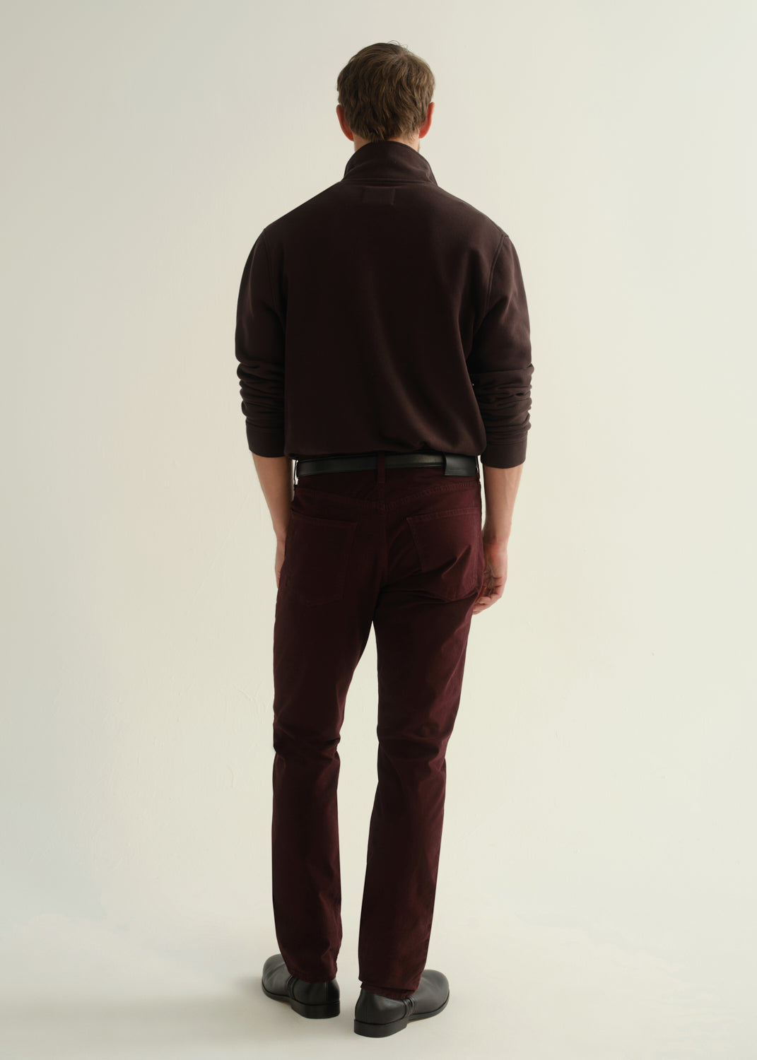 Man wearing Citizens of Humanity Gage slim straight burgundy sateen pants, rear view