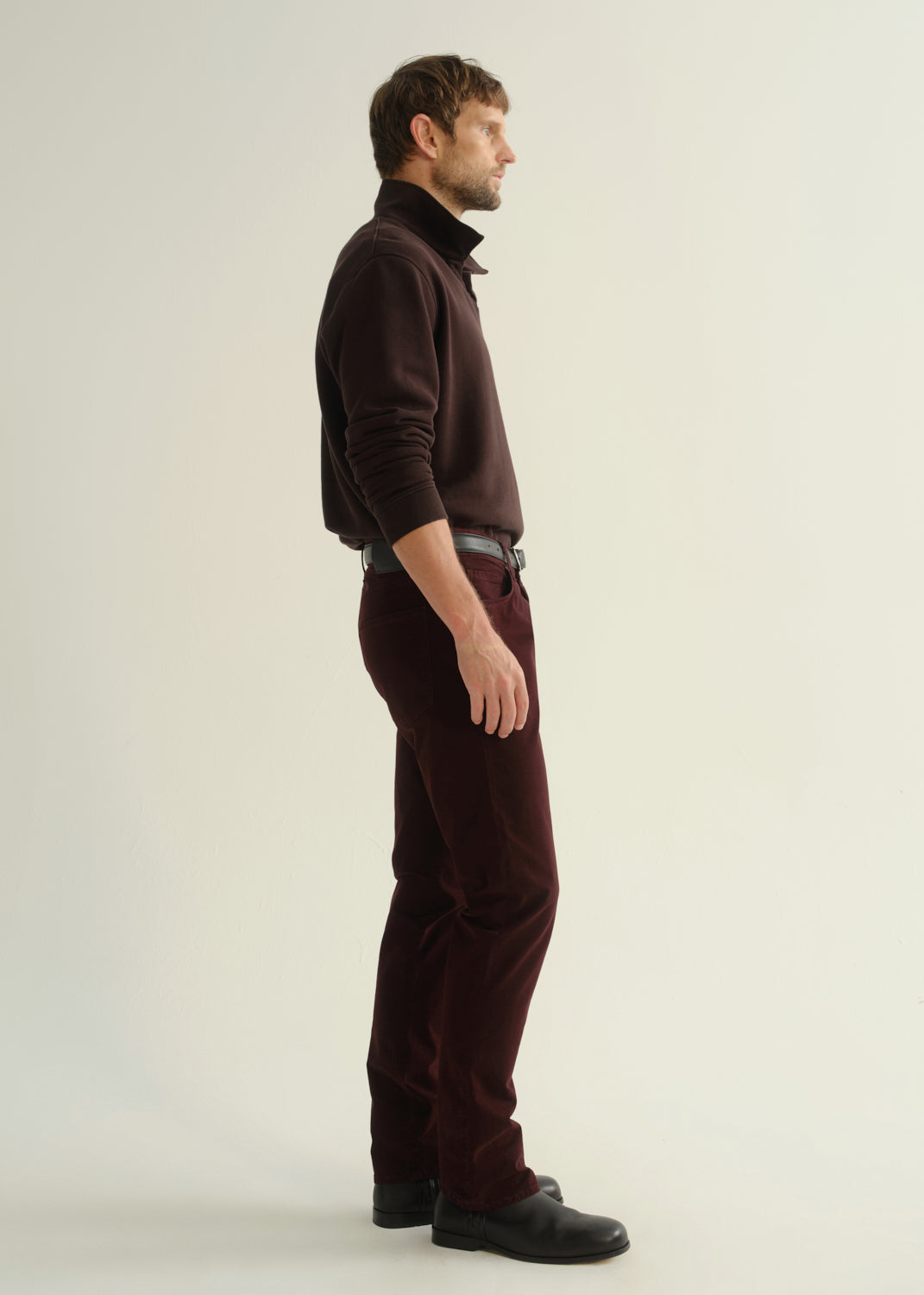 Male model wearing burgundy slim straight corduroy pants with matching turtleneck sweater