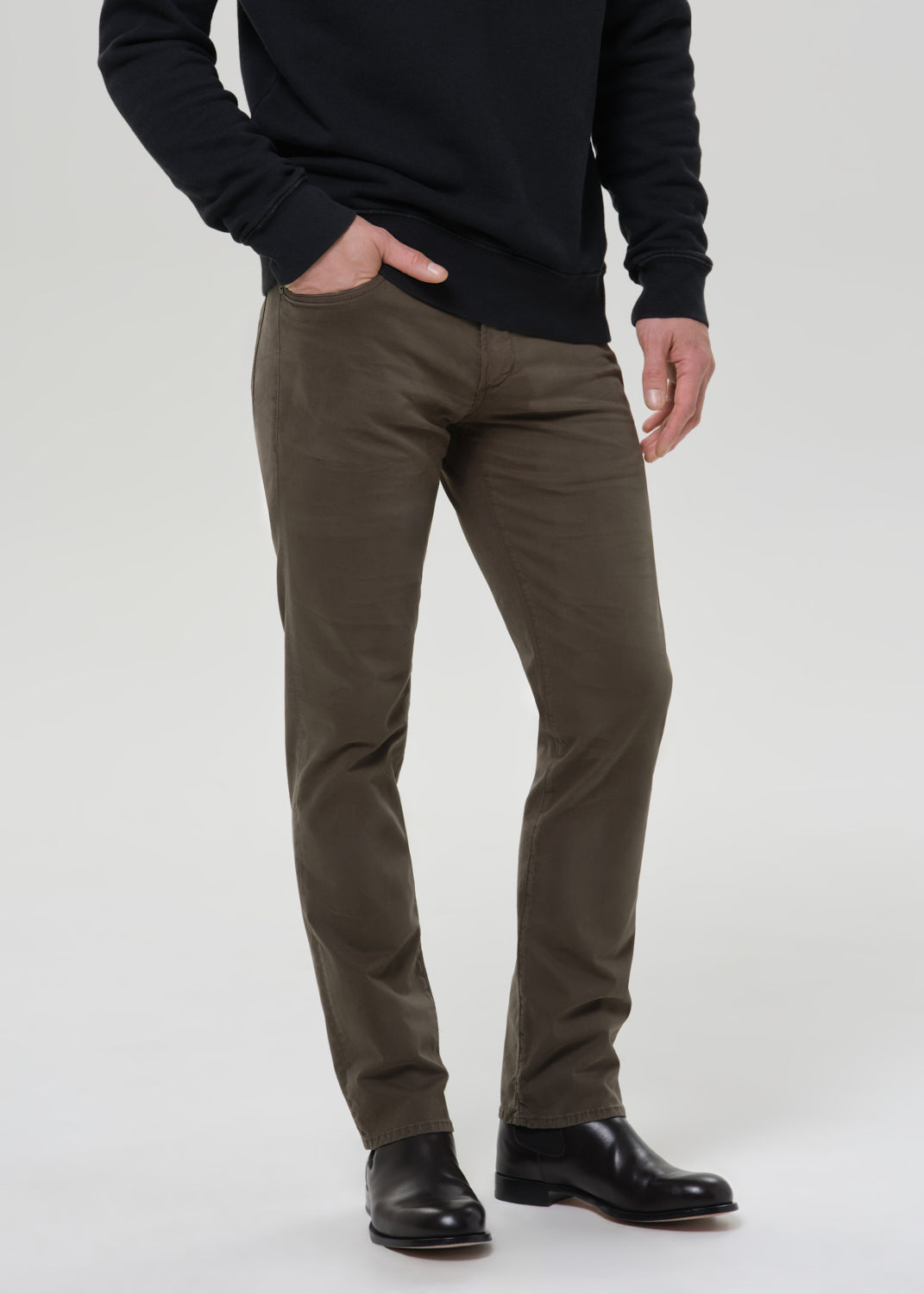 Model wearing Citizens of Humanity Gage slim straight olive sateen pants with black sweatshirt and boots