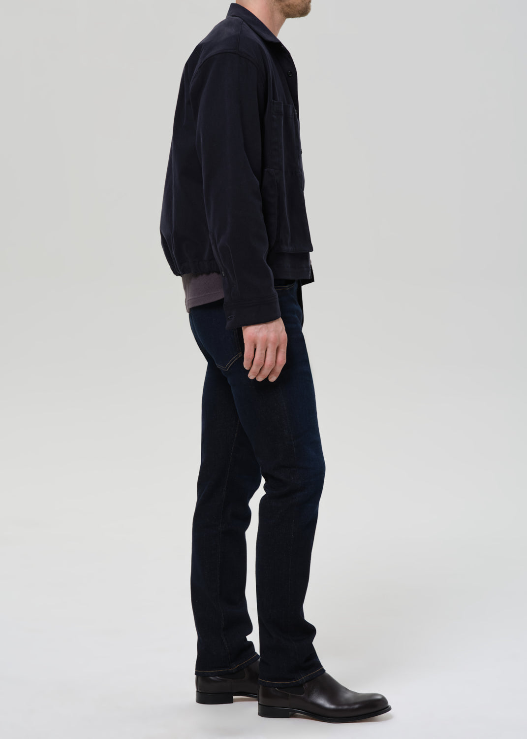 Male model wearing Citizens of Humanity Elijah relaxed straight cashmere denim jeans in dark indigo Falcon wash, side view