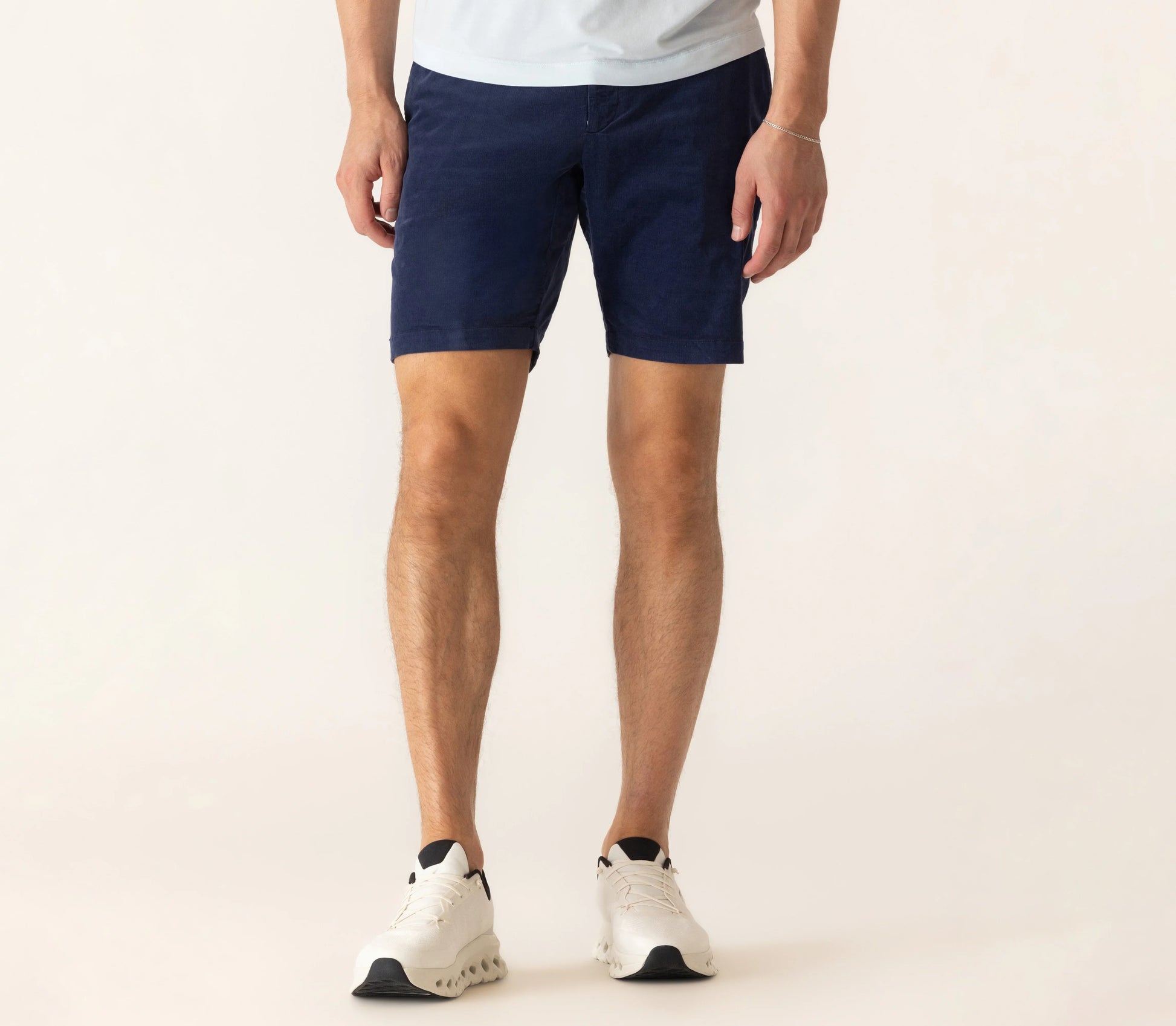 Model wearing navy blue corduroy bermuda shorts with white sneakers and t-shirt