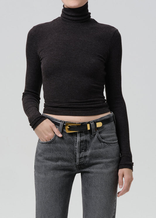 Model wearing a dark heather charcoal ribbed turtleneck cropped long-sleeve top with grey jeans