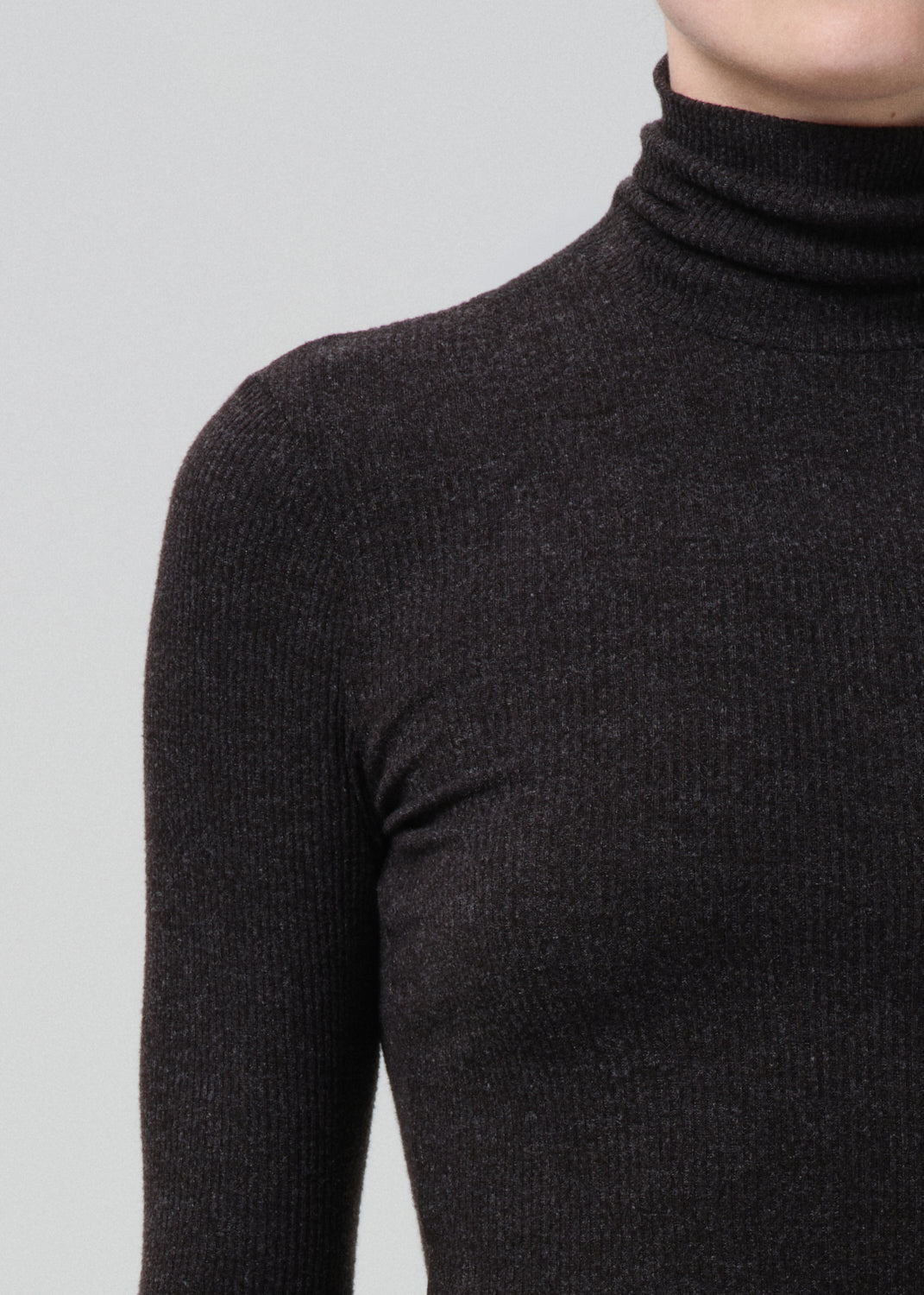 Close-up of a fitted heather charcoal ribbed turtleneck sweater on a model