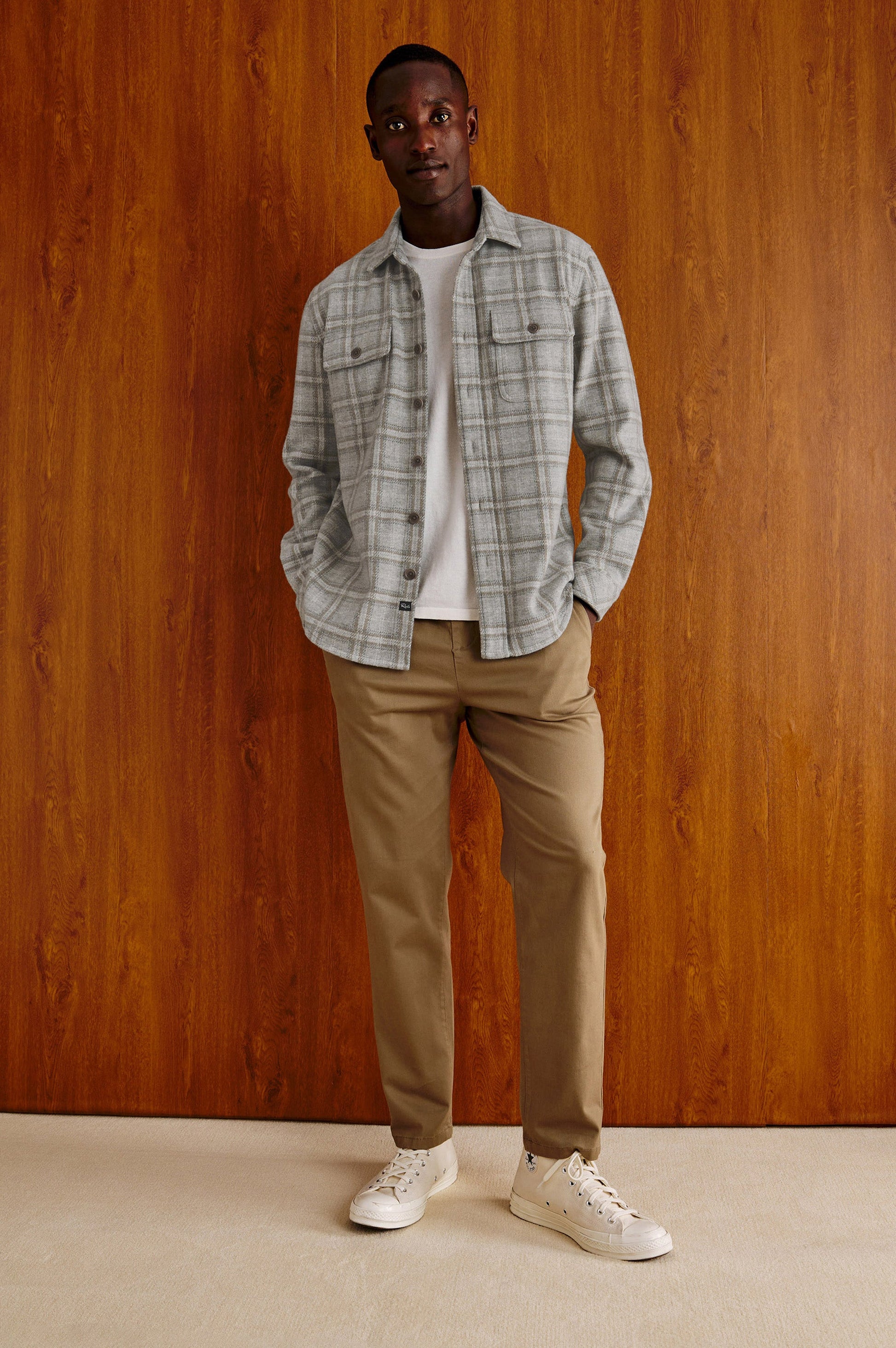 Male model wearing Rails Alder grey plaid overshirt with khaki trousers and white sneakers