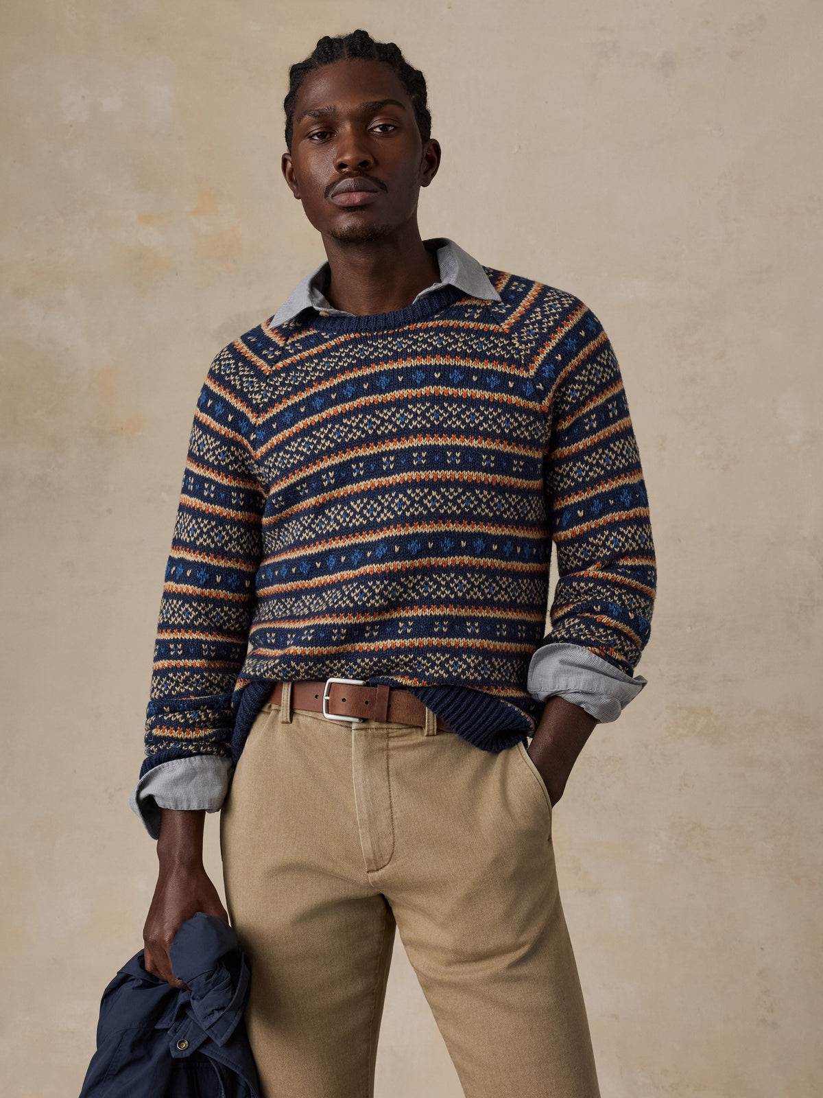 Male model wearing Faherty Nordic Sweater Crew in Northern Nights Fairisle pattern with khaki trousers