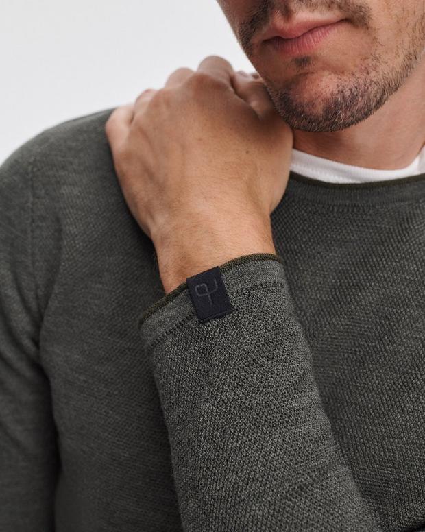 Man wearing Rag & Bone Brooks Merino Wool Crewneck in army green with visible sleeve label
