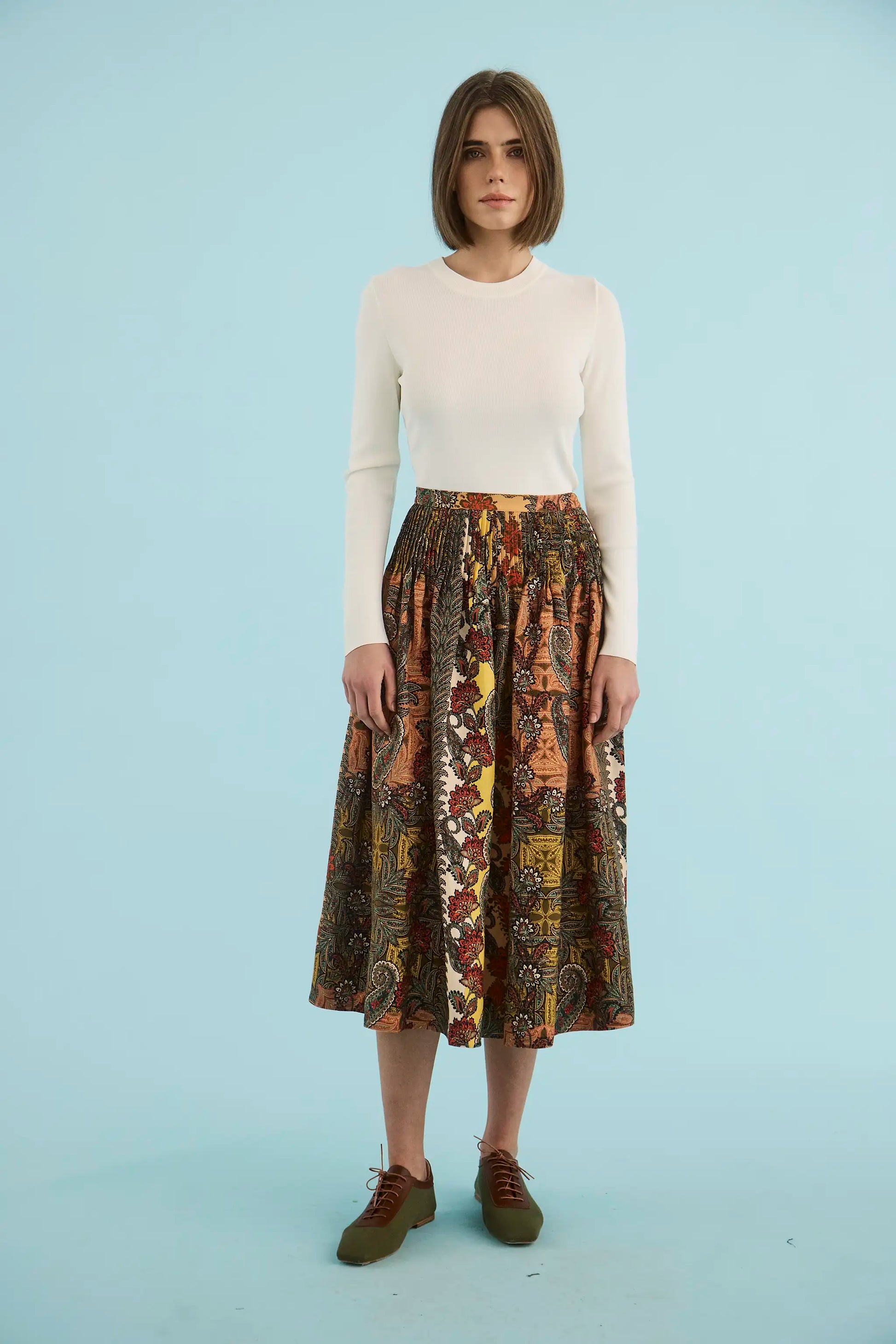 Model wearing Hunter Bell Fallon Skirt in Highland Tapestry print with ivory sweater