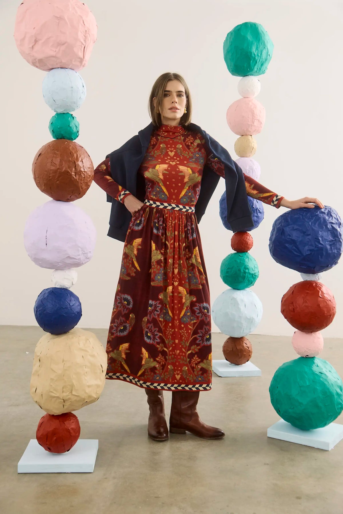 Model wearing maroon Birds of a Feather printed midi skirt with navy blazer and brown boots