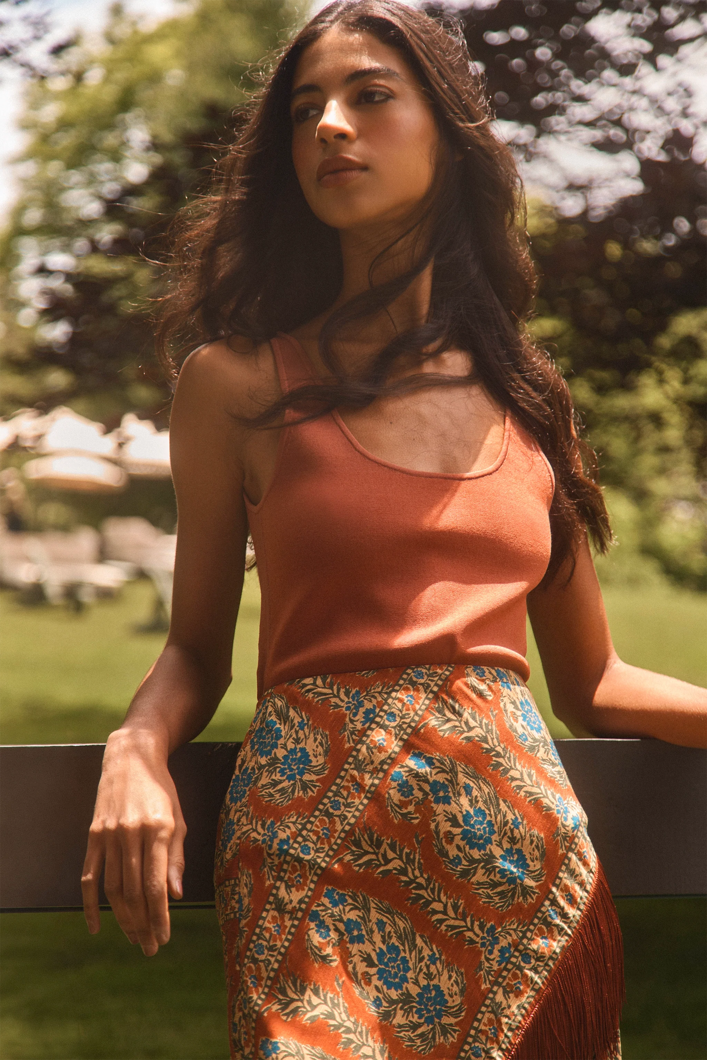 Model wearing Hunter Bell Davis Cami in rust orange with floral printed skirt outdoors