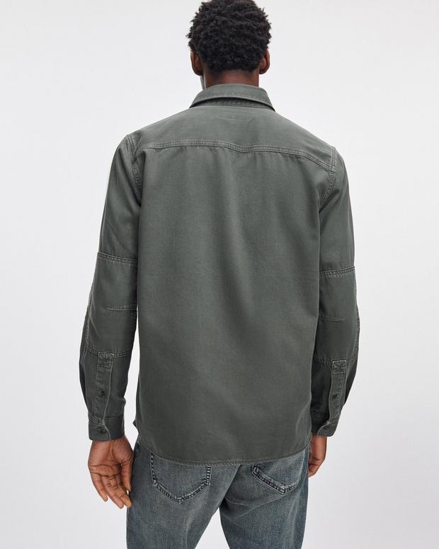 Back view of male model wearing dark green Rag & Bone denim workwear shirt with jeans
