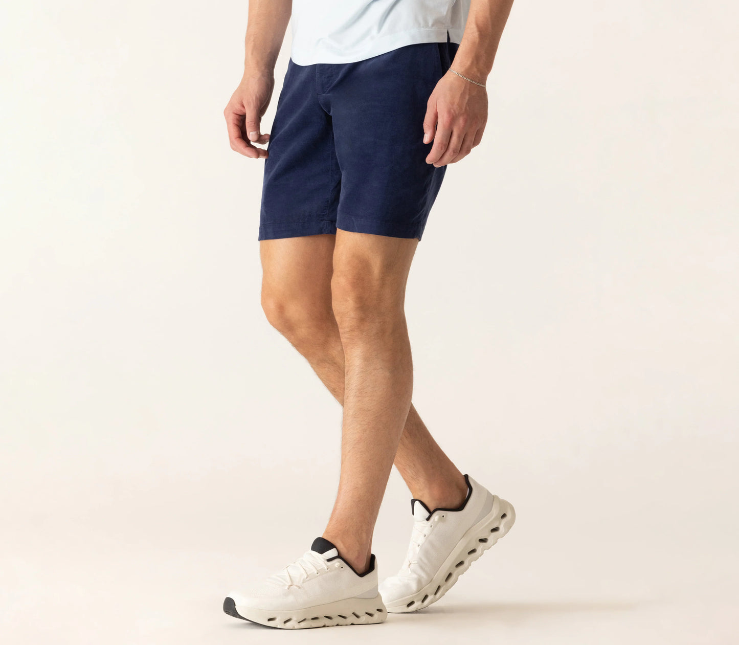 Man wearing navy blue corduroy bermuda shorts with white sneakers in lifestyle photo