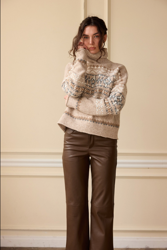 Model wearing a beige Fair Isle turtleneck sweater with brown leather flare pants