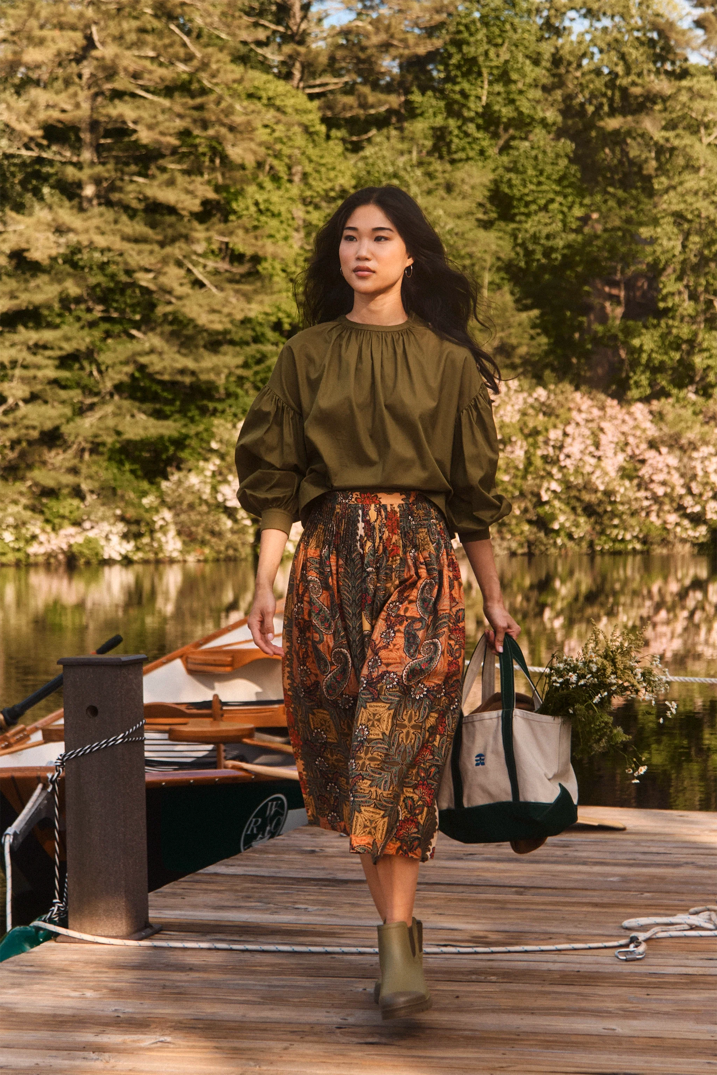 Model wearing Hunter Bell Fallon Skirt in Highland Tapestry print on a lakeside dock