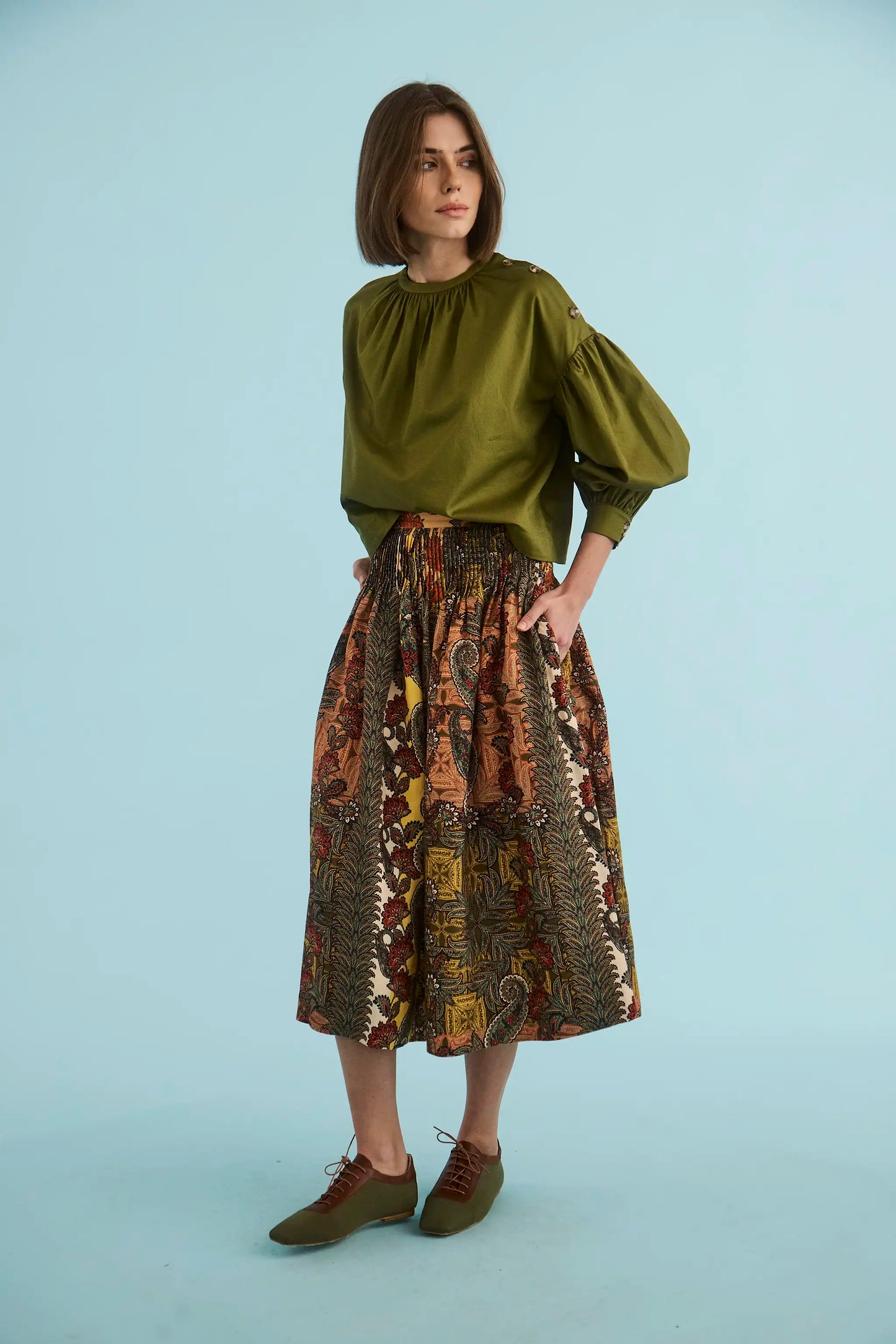 Model wearing Hunter Bell Fallon Skirt in Highland Tapestry print with olive green blouse